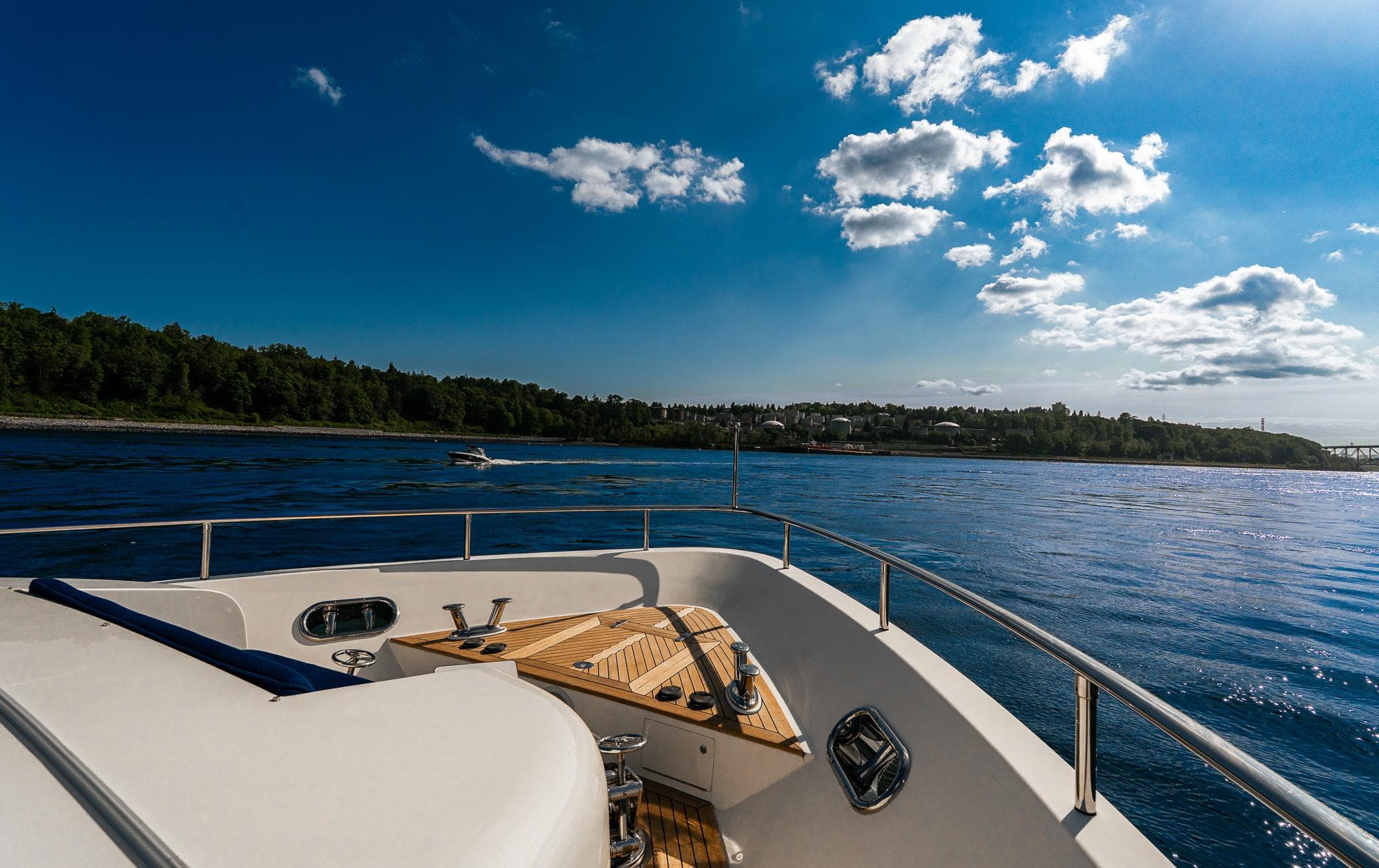 Luxury yacht Mystica Skylounge 2007 cruising on a sunny day with scenic coastal view.
