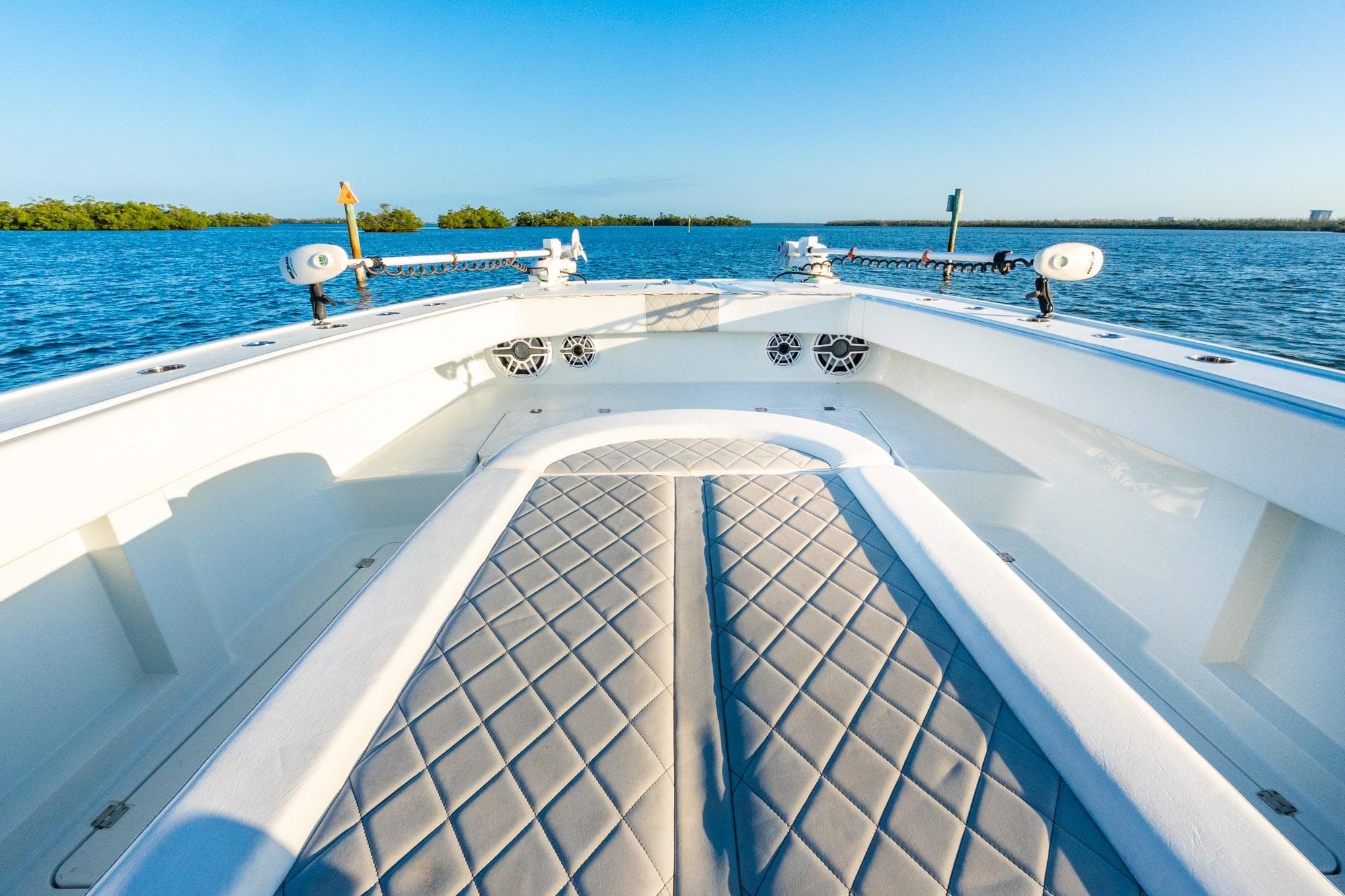 Luxurious 2022 Freeman 42LR boat interior with diamond-stitched seating on calm blue waters.