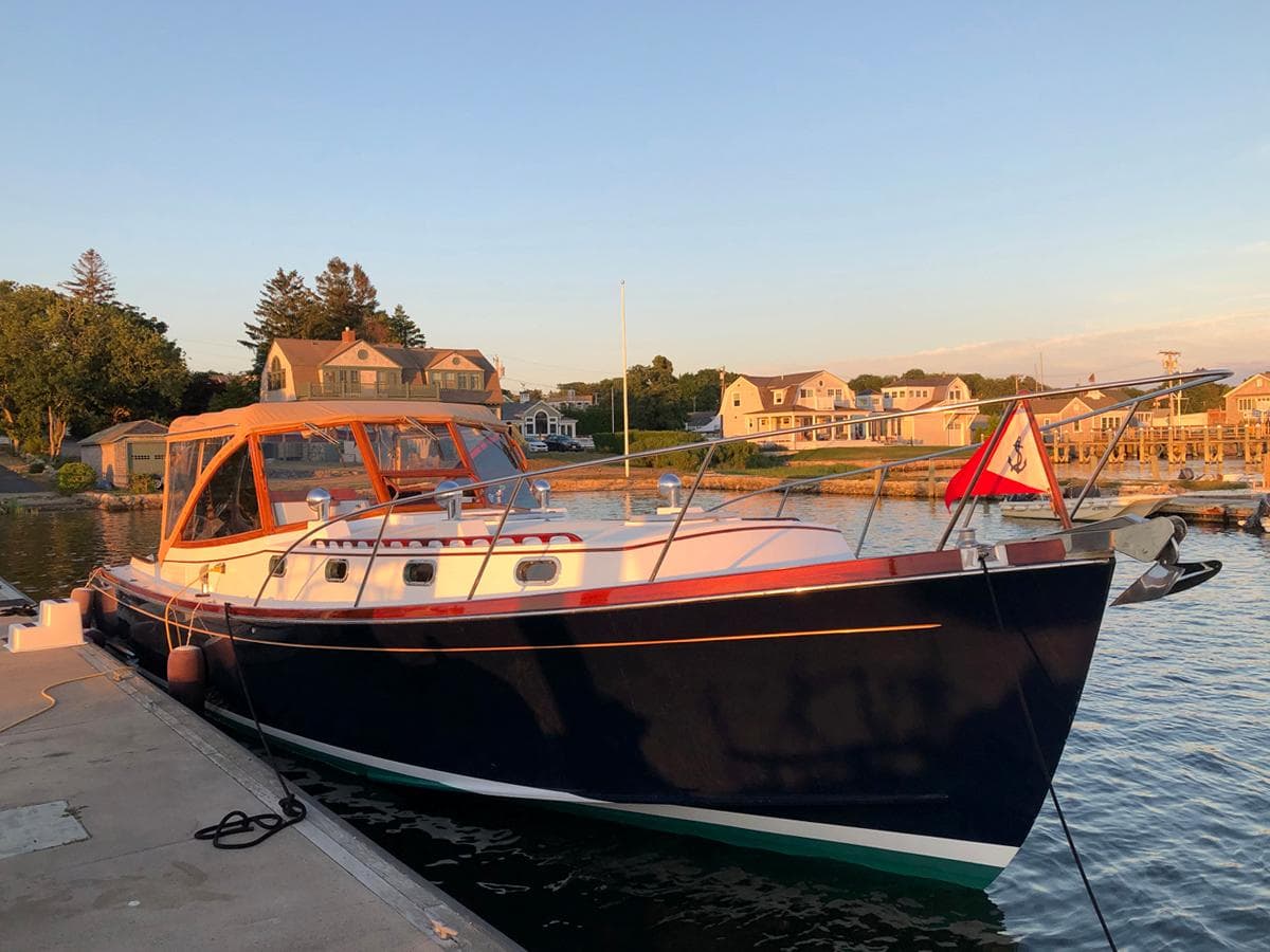 Classic 1995 Able 44 yacht docked at a scenic marina during sunset.