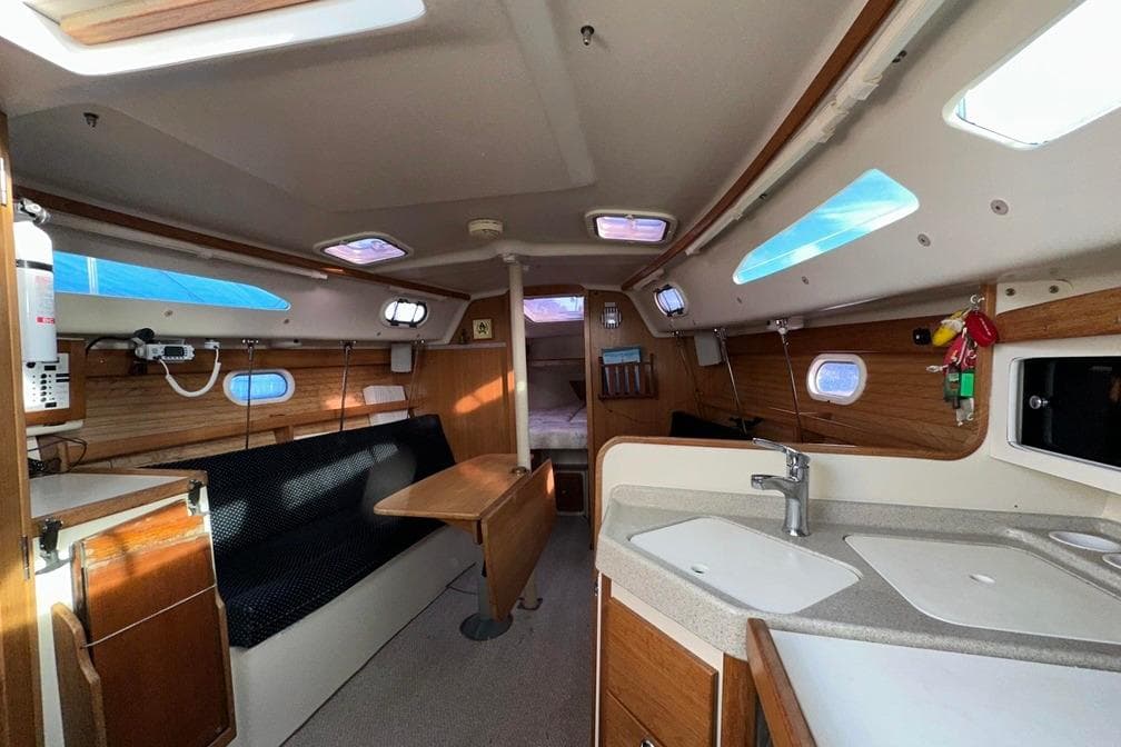 Interior of a 2005 Catalina 28 MkII sailboat, featuring a cozy cabin and kitchenette.