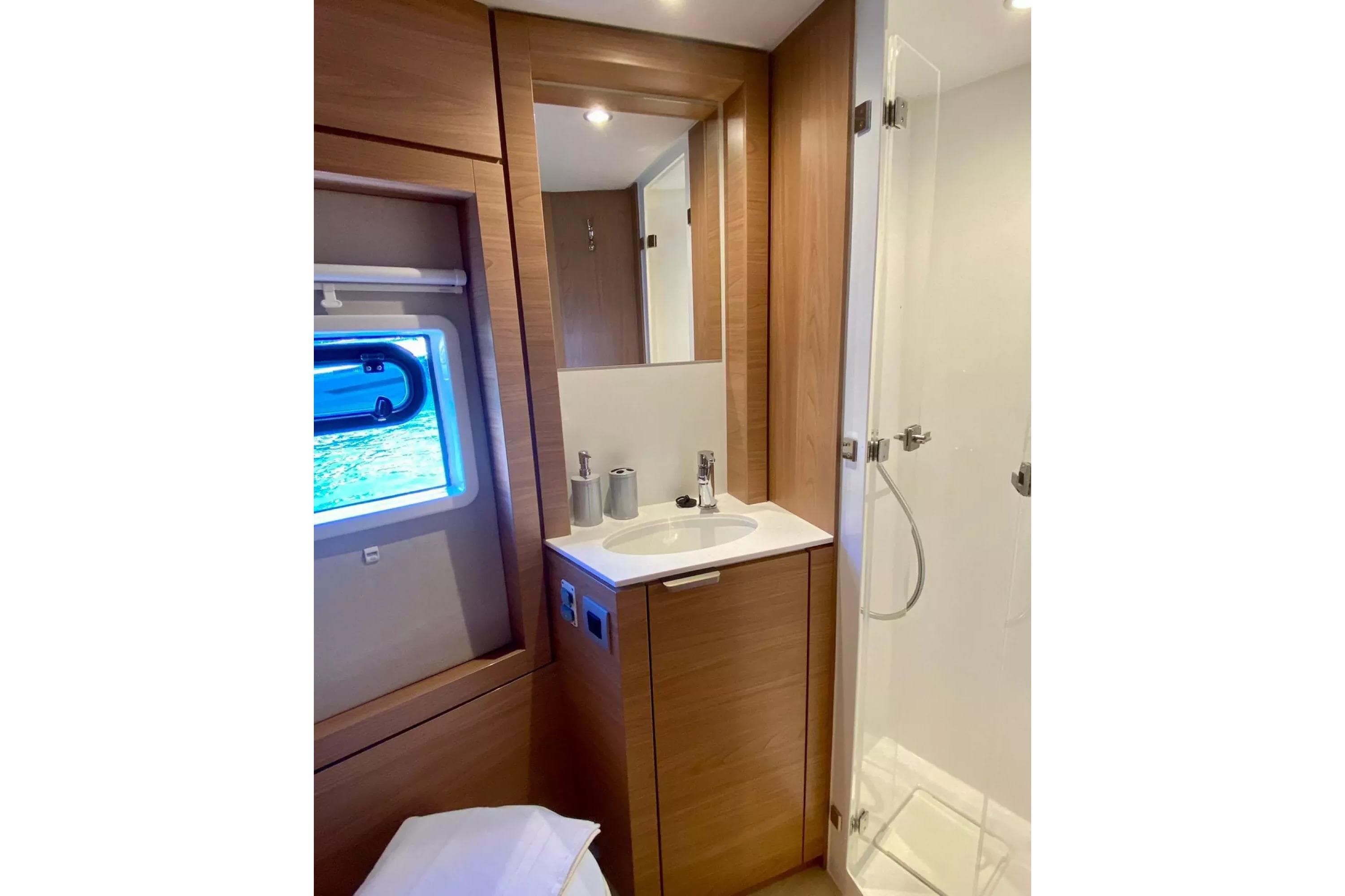 Modern bathroom interior on 2024 Bali 4.4 yacht, featuring wood accents and sleek fixtures.