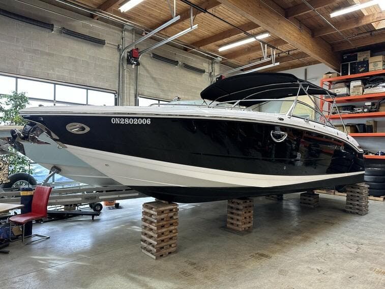 2011 Cobalt 296 boat in a garage, elevated on blocks.