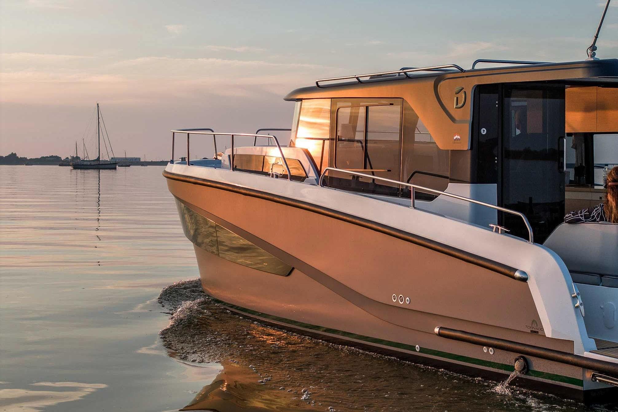 2026 Delphia D10 Sedan cruising on calm waters at sunset.