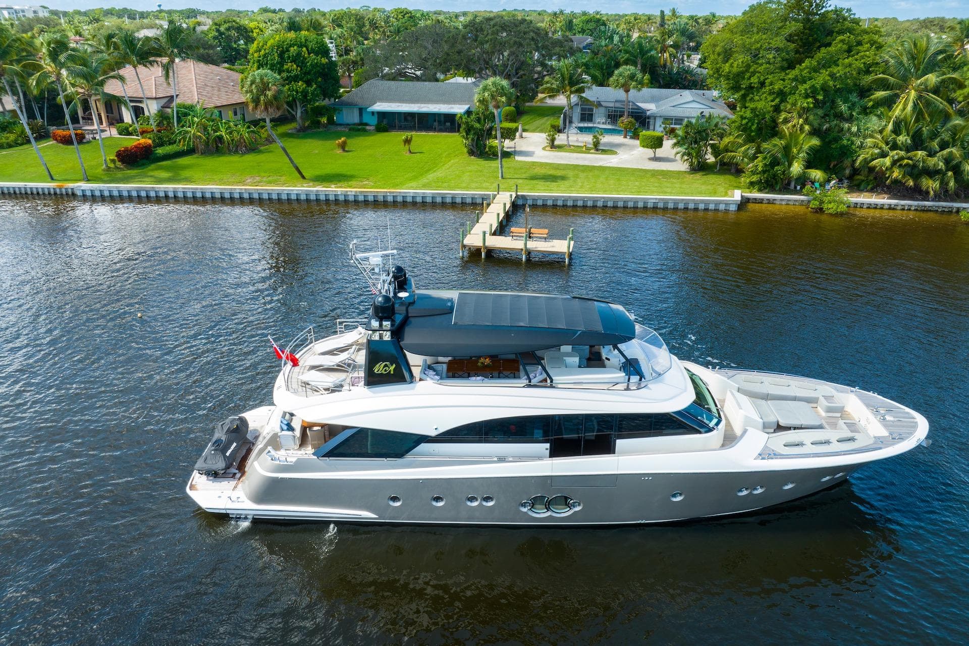Luxurious 2015 Monte Carlo Yachts MCY 86 cruising on a serene waterfront.