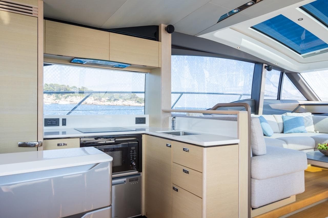 Luxurious interior of 2019 Princess V60 yacht with modern kitchen and seating area.
