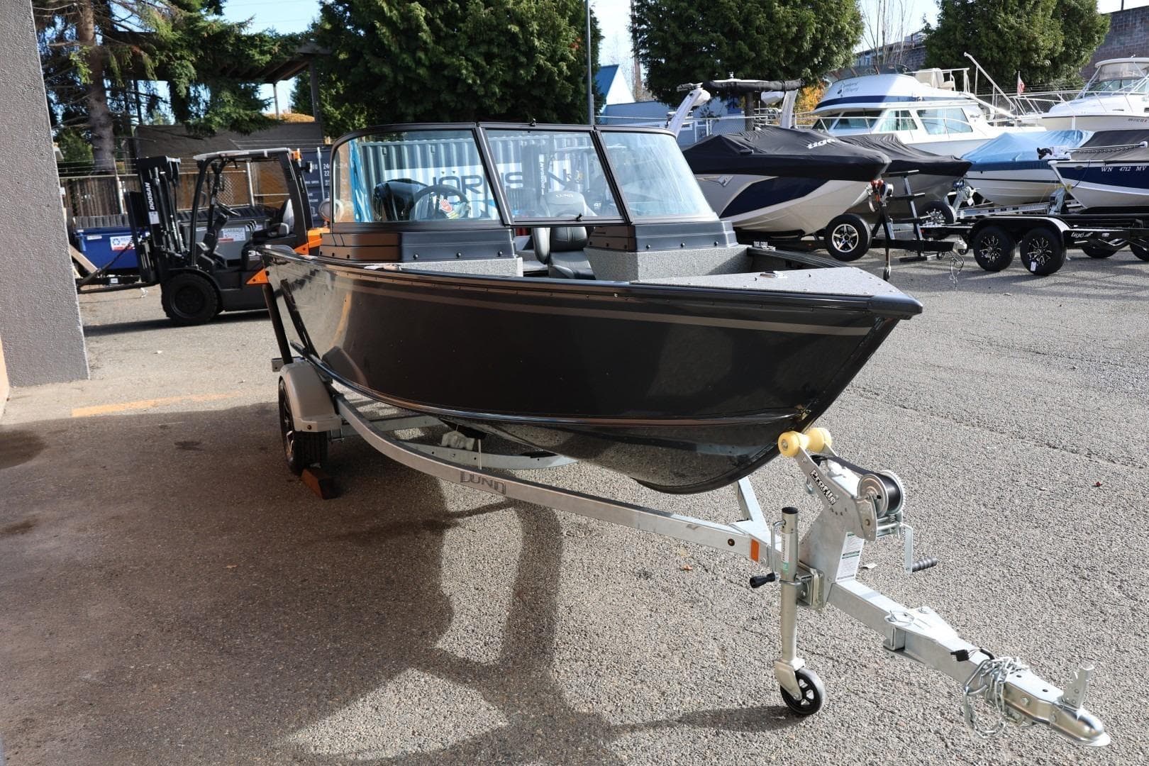 2026 Lund 1675 Adventure Sport boat on trailer, parked outdoors.