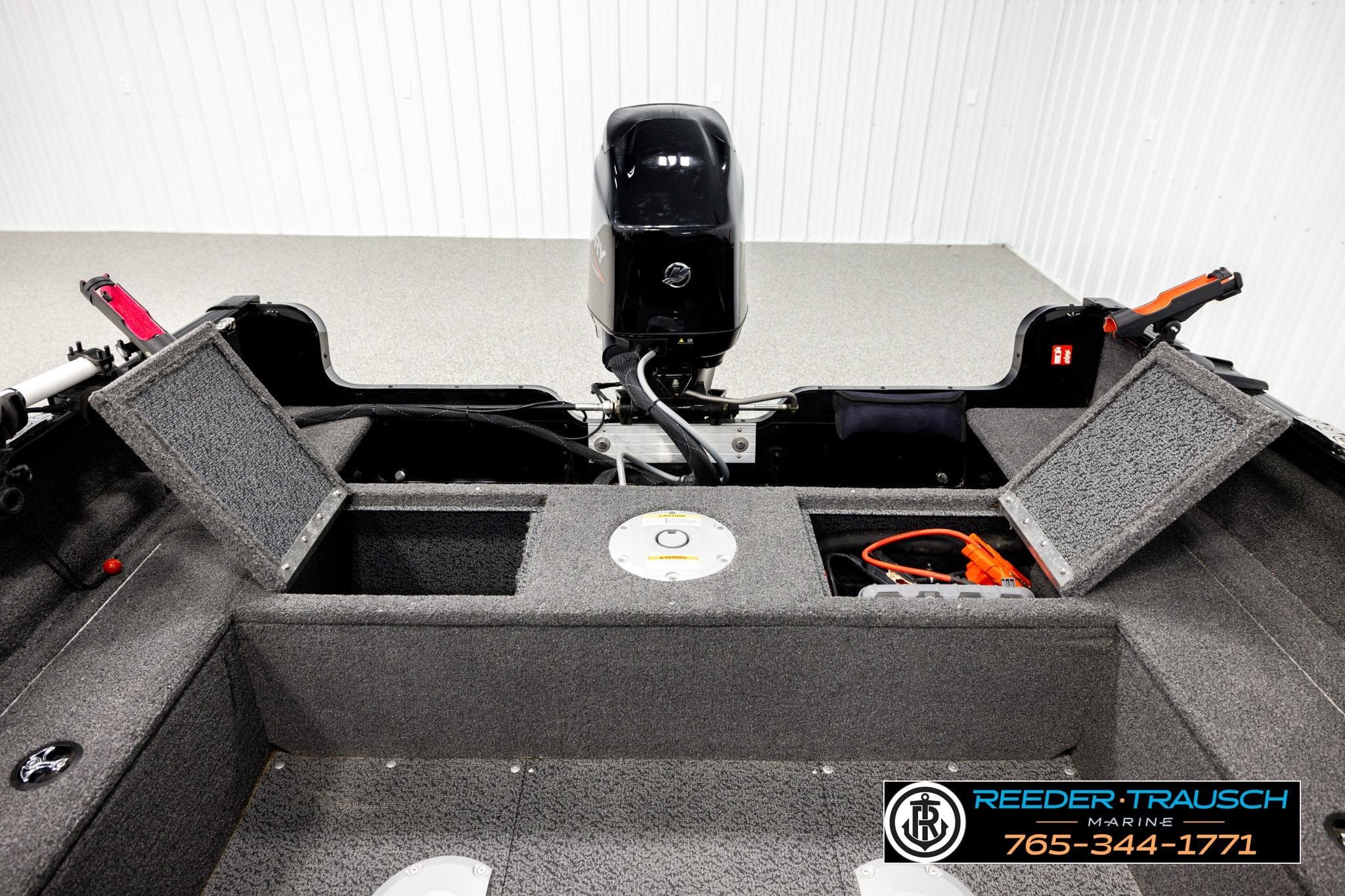 2025 Lund 1650 Rebel XL SS boat interior with open storage compartments and motor.