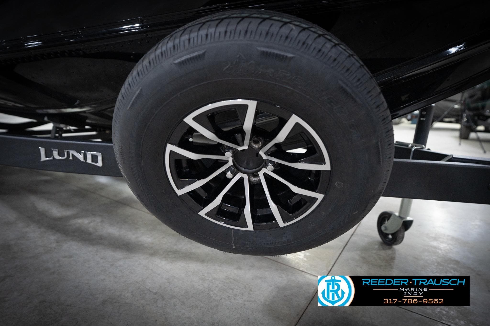 2026 Lund 2275 Baron trailer wheel with sleek black and silver design.