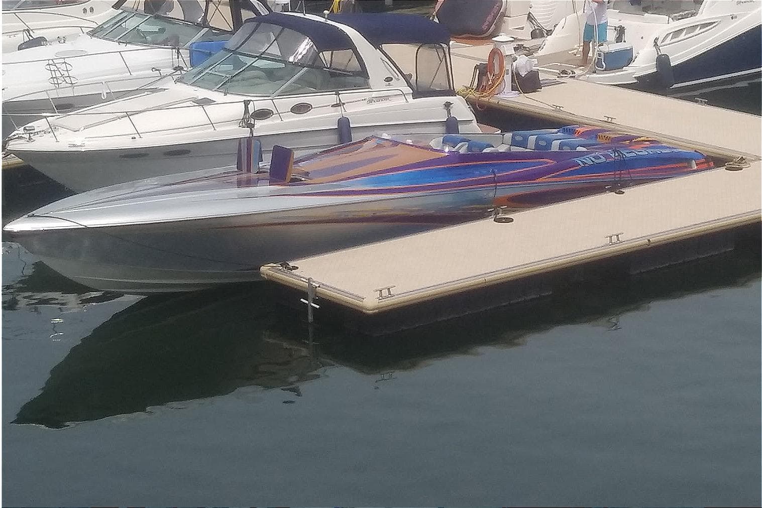 2004 Outerlimits 42 Legacy speedboat docked at marina, featuring sleek design and vibrant colors.