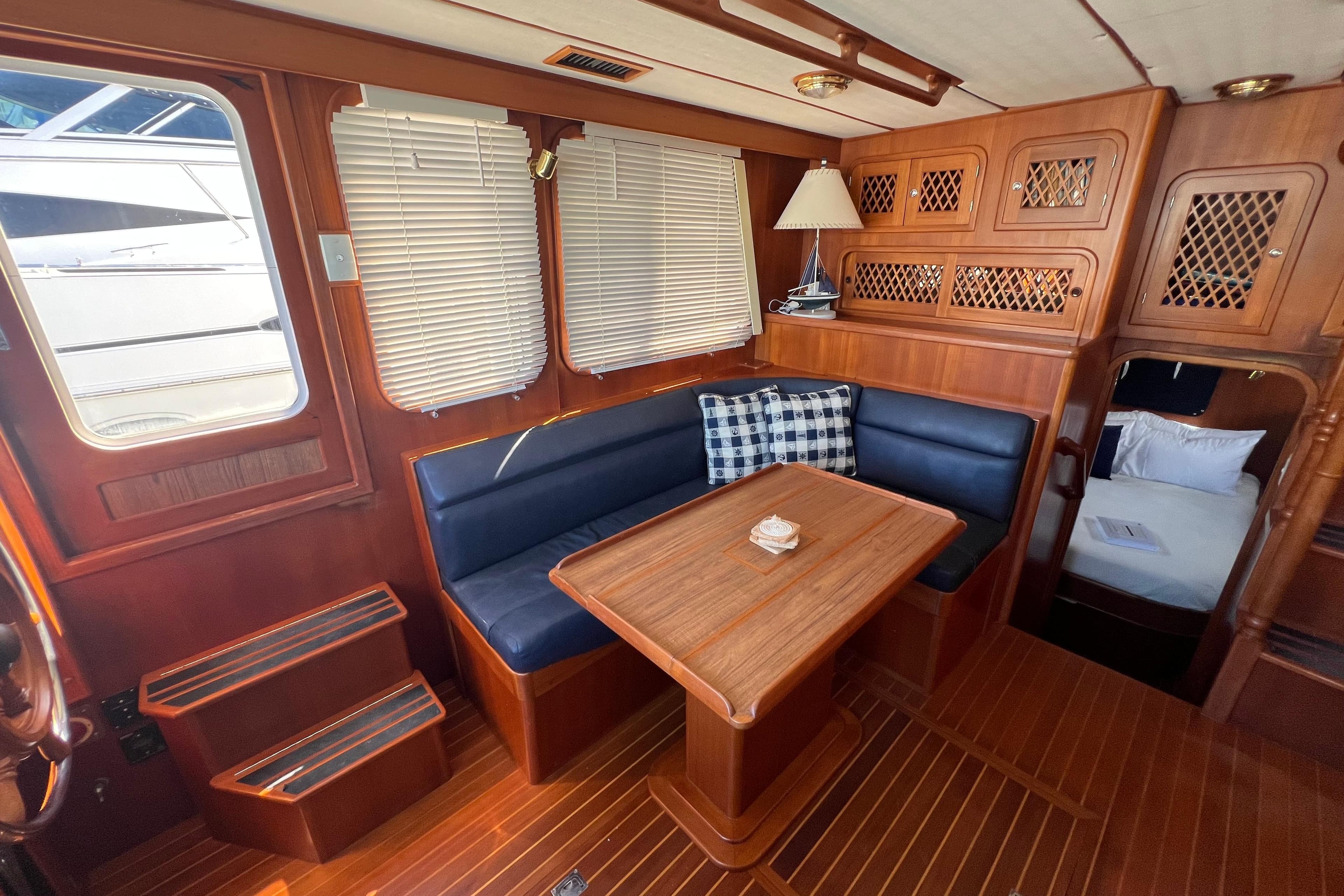 Interior of 2007 Heritage East Sundeck Trawler with wood finish and cozy seating area.