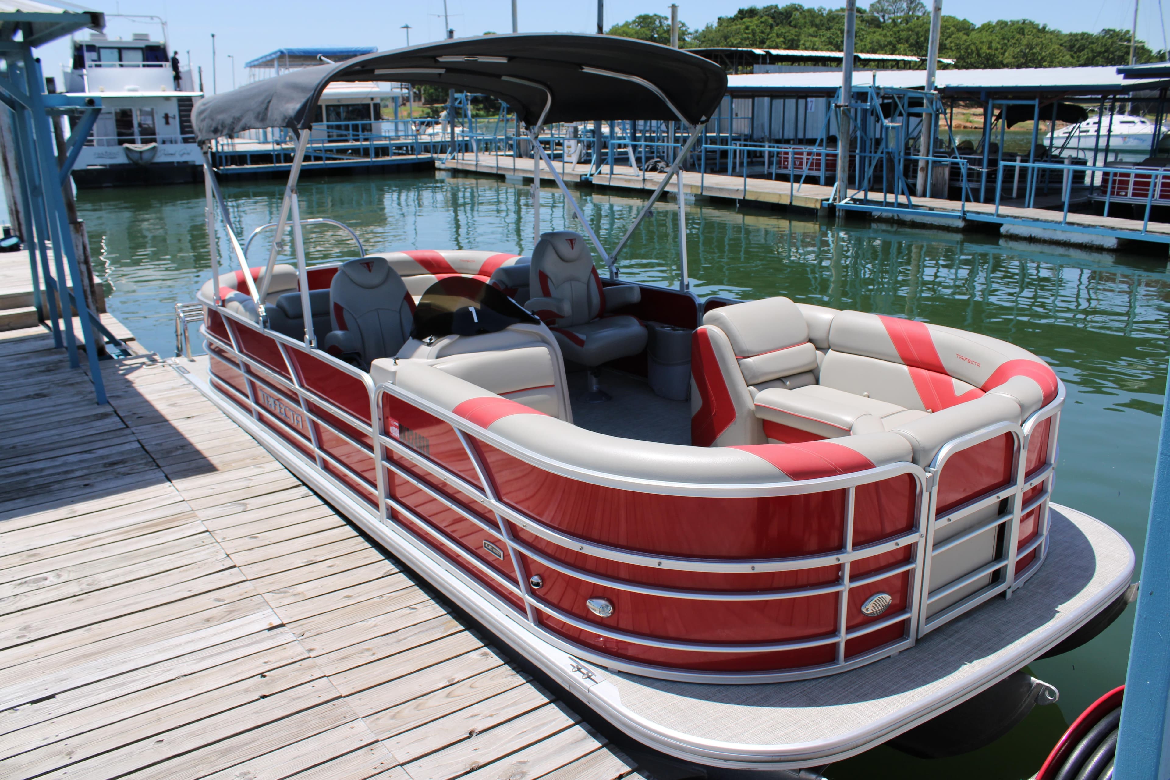 2022 Trifecta 24RFLE pontoon boat docked, featuring red and beige seating with a canopy.