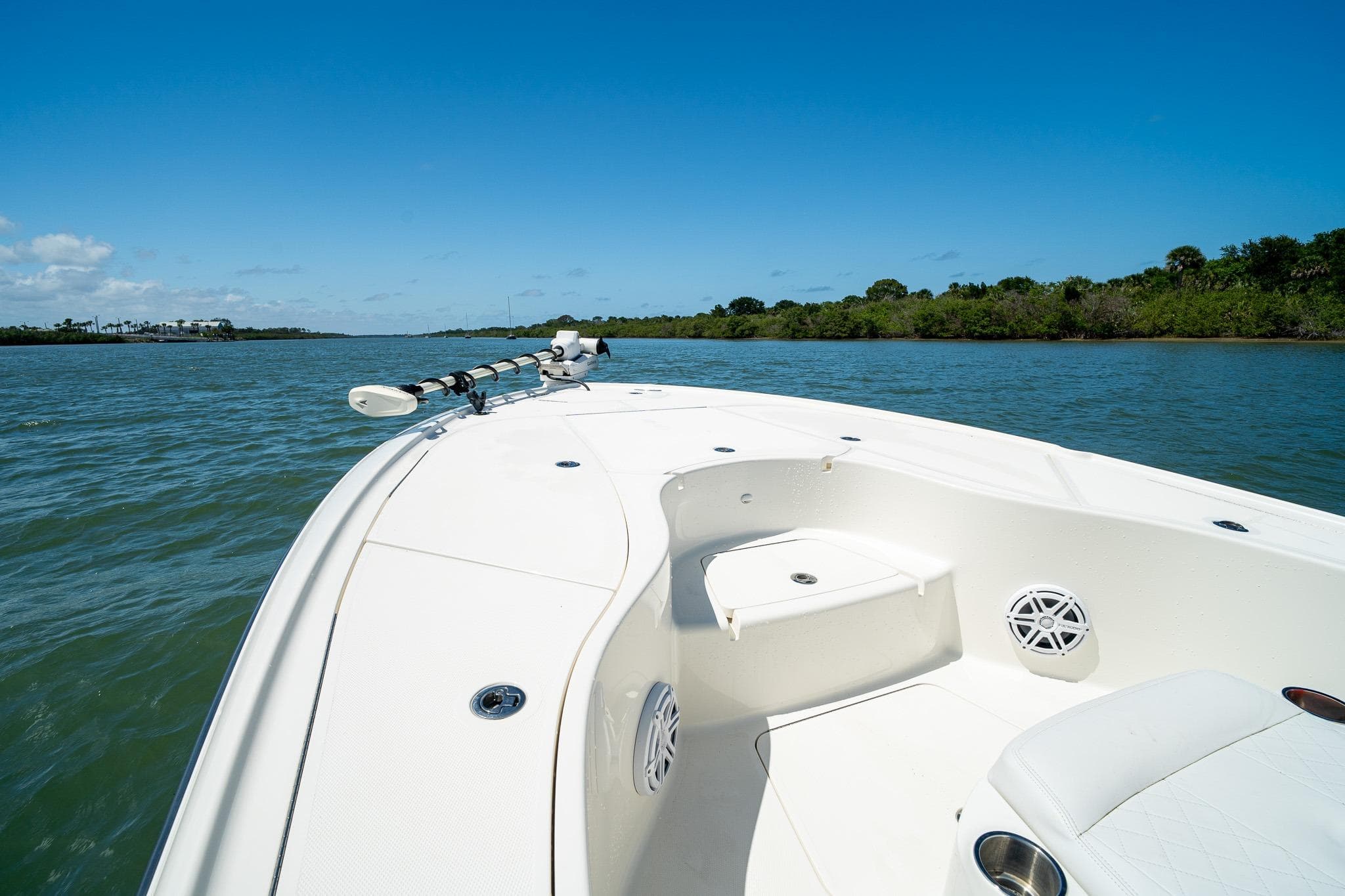2018 SeaVee 270Z boat cruising on a sunny day, surrounded by calm waters and lush greenery.