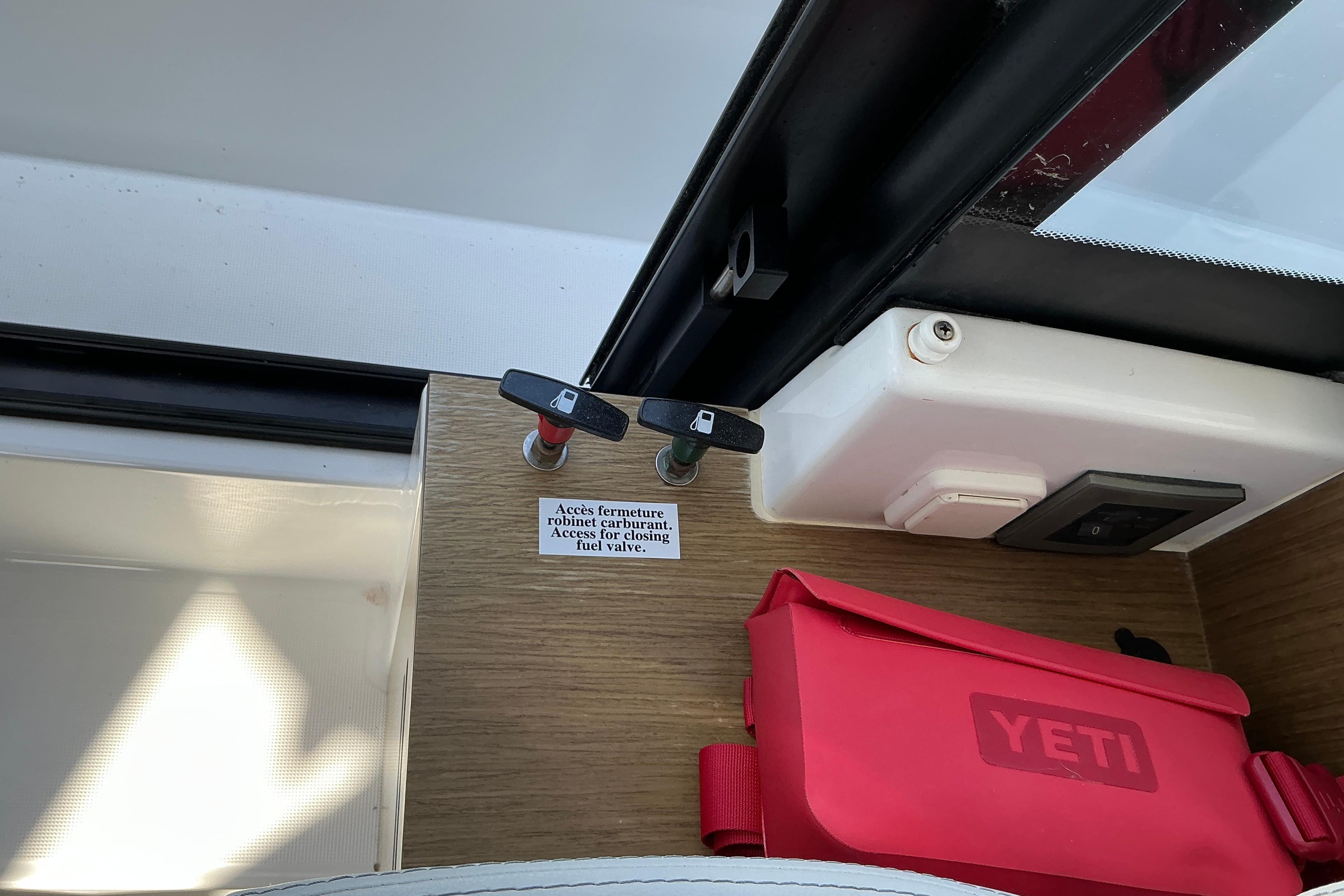 Fuel valve access on 2022 Beneteau Antares 9 boat, with red Yeti bag nearby.