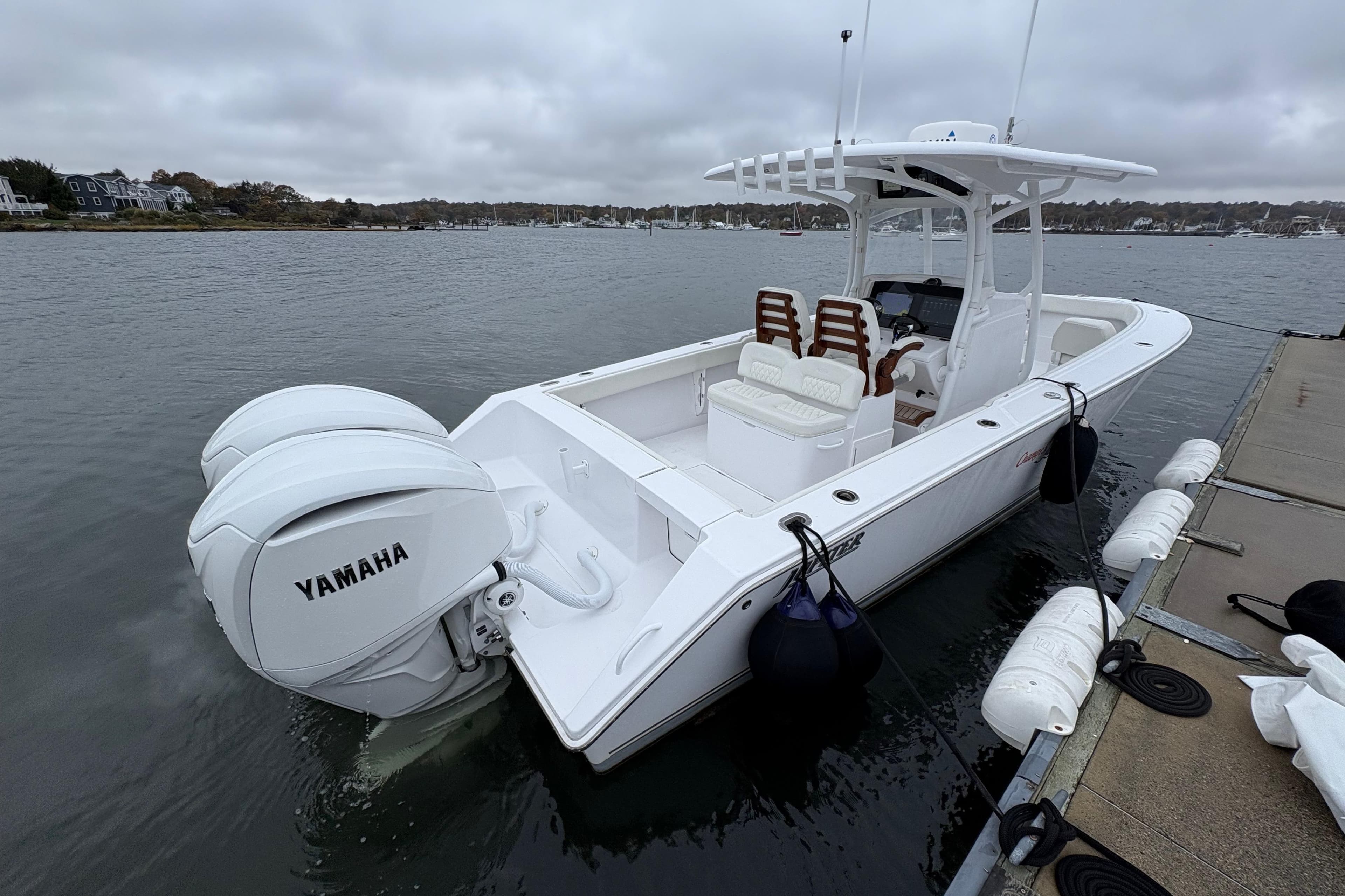 2023 Jupiter 30 boat docked with twin Yamaha engines, overcast sky.