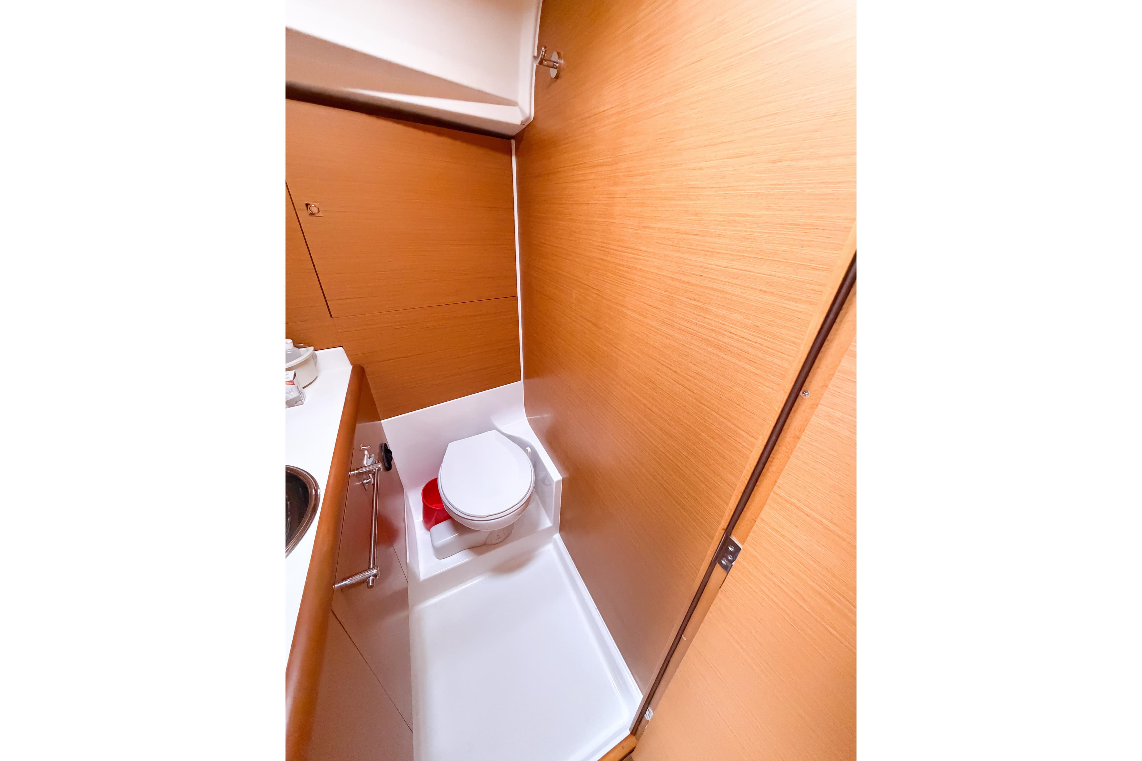 2013 Jeanneau Sun Odyssey 409 yacht bathroom with wooden paneling and compact toilet.