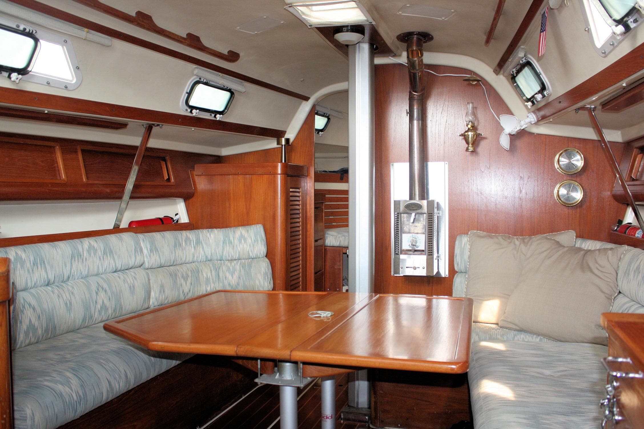 Interior of a 1988 Pearson 31 sailboat with cozy seating and wooden finishes.