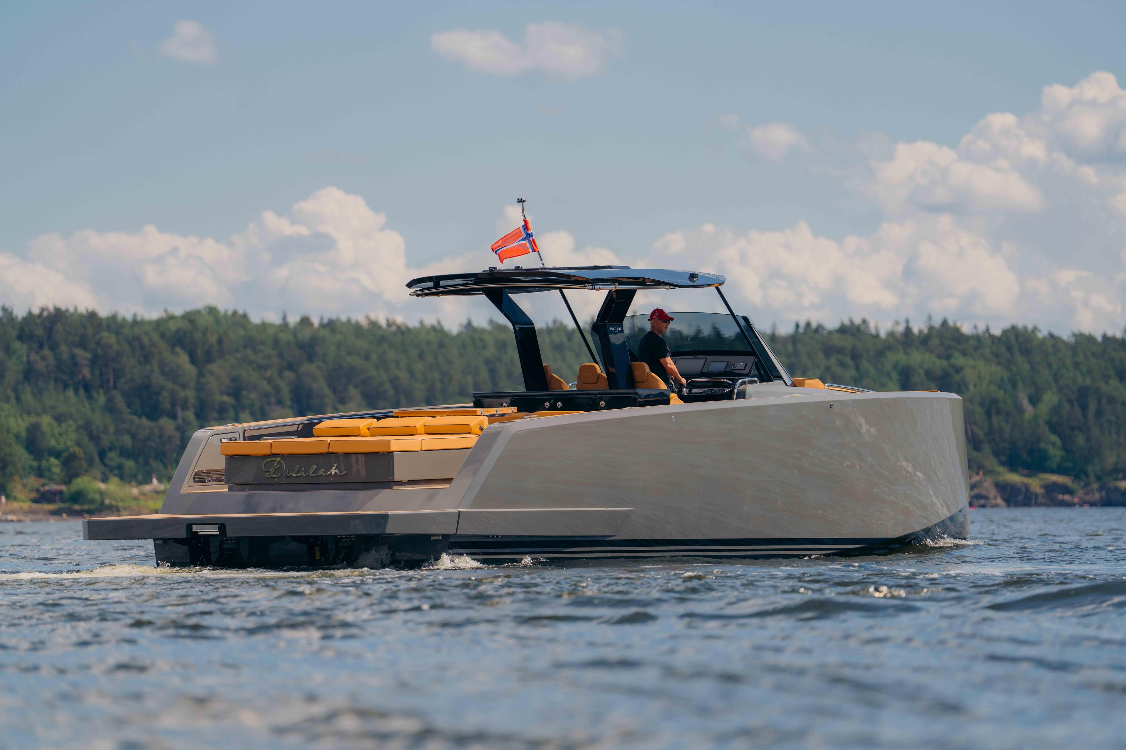 2024 Pardo Yachts P43 cruising on a serene lake with lush forest backdrop.