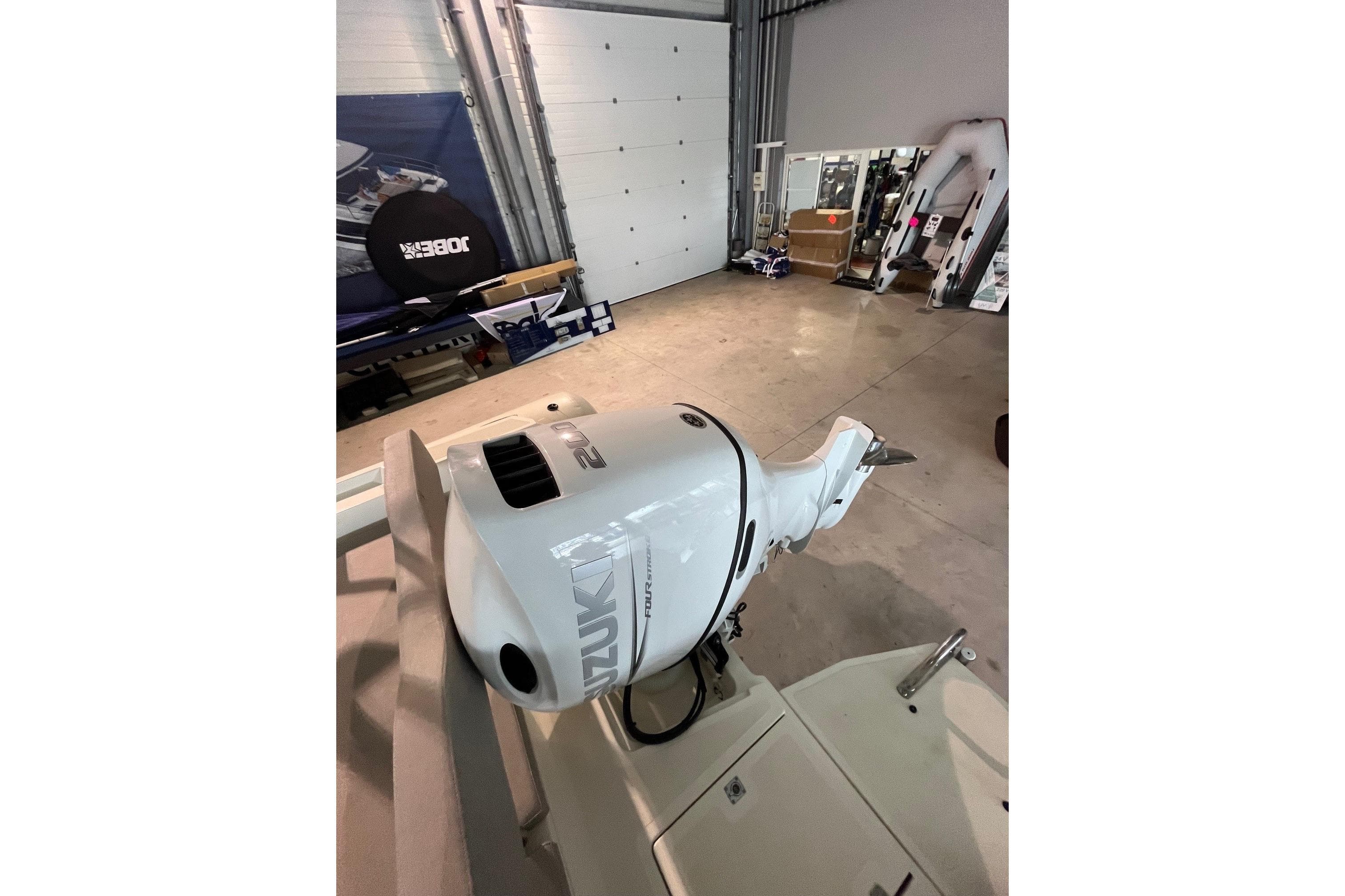 2023 Nuova Jolly 700 XL with Suzuki outboard motor in a garage setting.