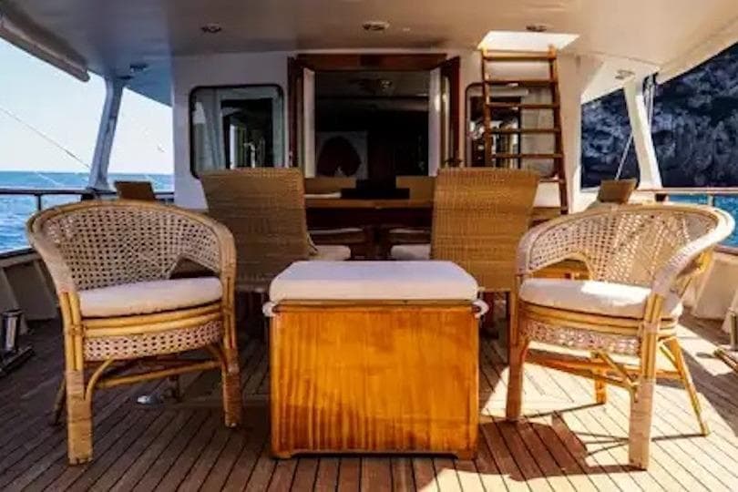 Elegant 1964 Costaguta Classic Motor Yacht deck with wicker chairs and ocean view.