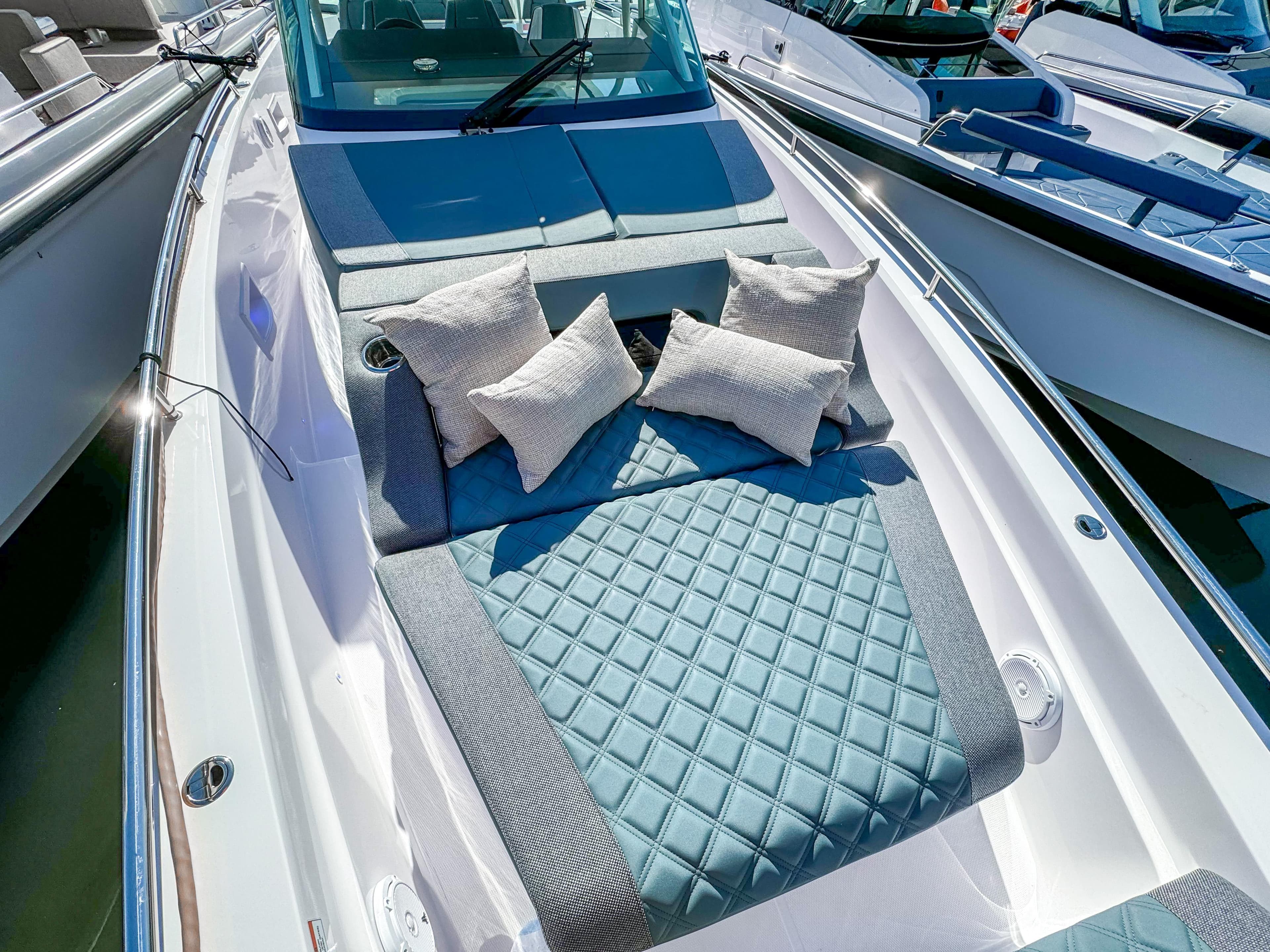 2024 Axopar 37 Sun Top boat with luxurious sunbed and cushions on deck.