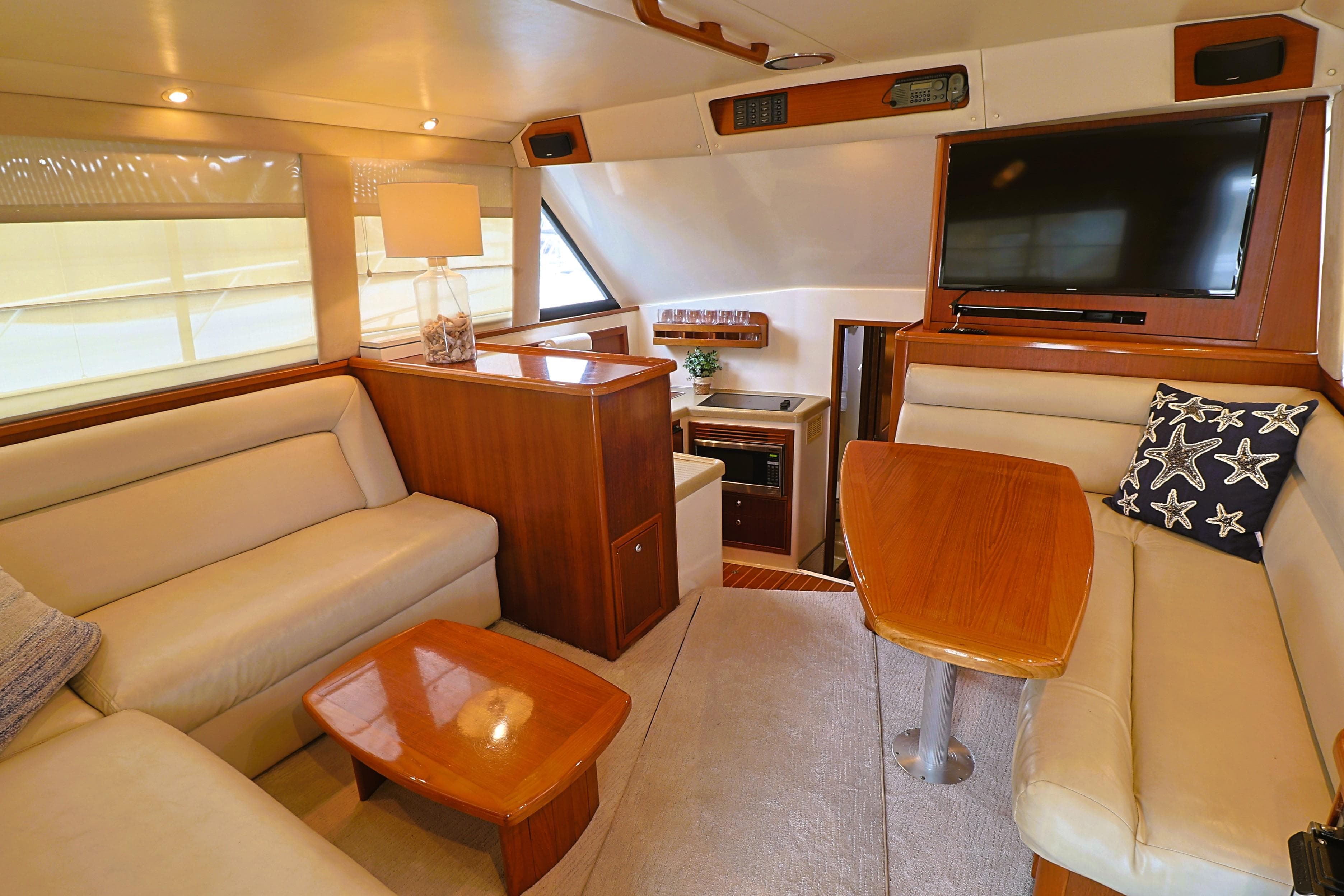 Luxurious interior of 2000 Riviera Flybridge Convertible yacht with plush seating and modern amenities.