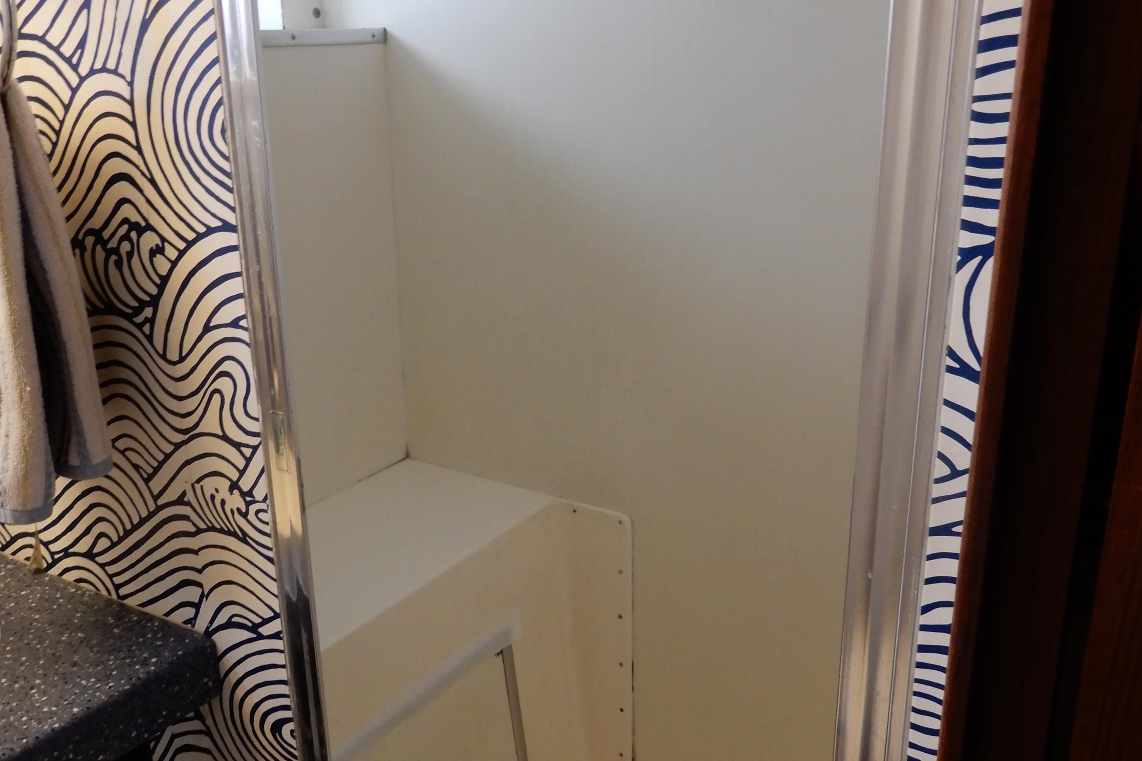 Interior of 1979 Hatteras 53 Motor Yacht with wave-patterned wallpaper and compact storage.