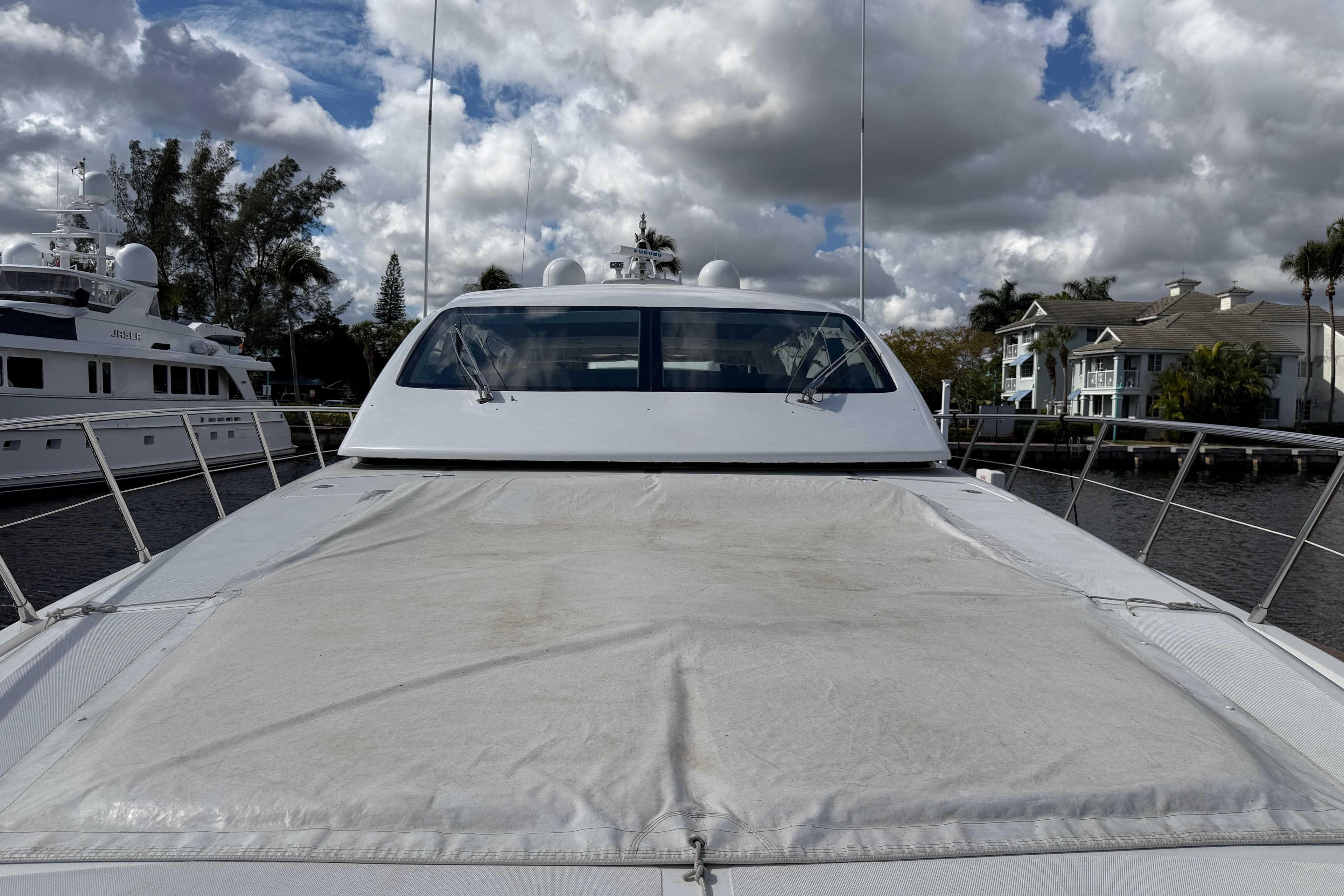 2004 Mangusta 72 yacht docked under cloudy skies, showcasing sleek design and spacious deck.