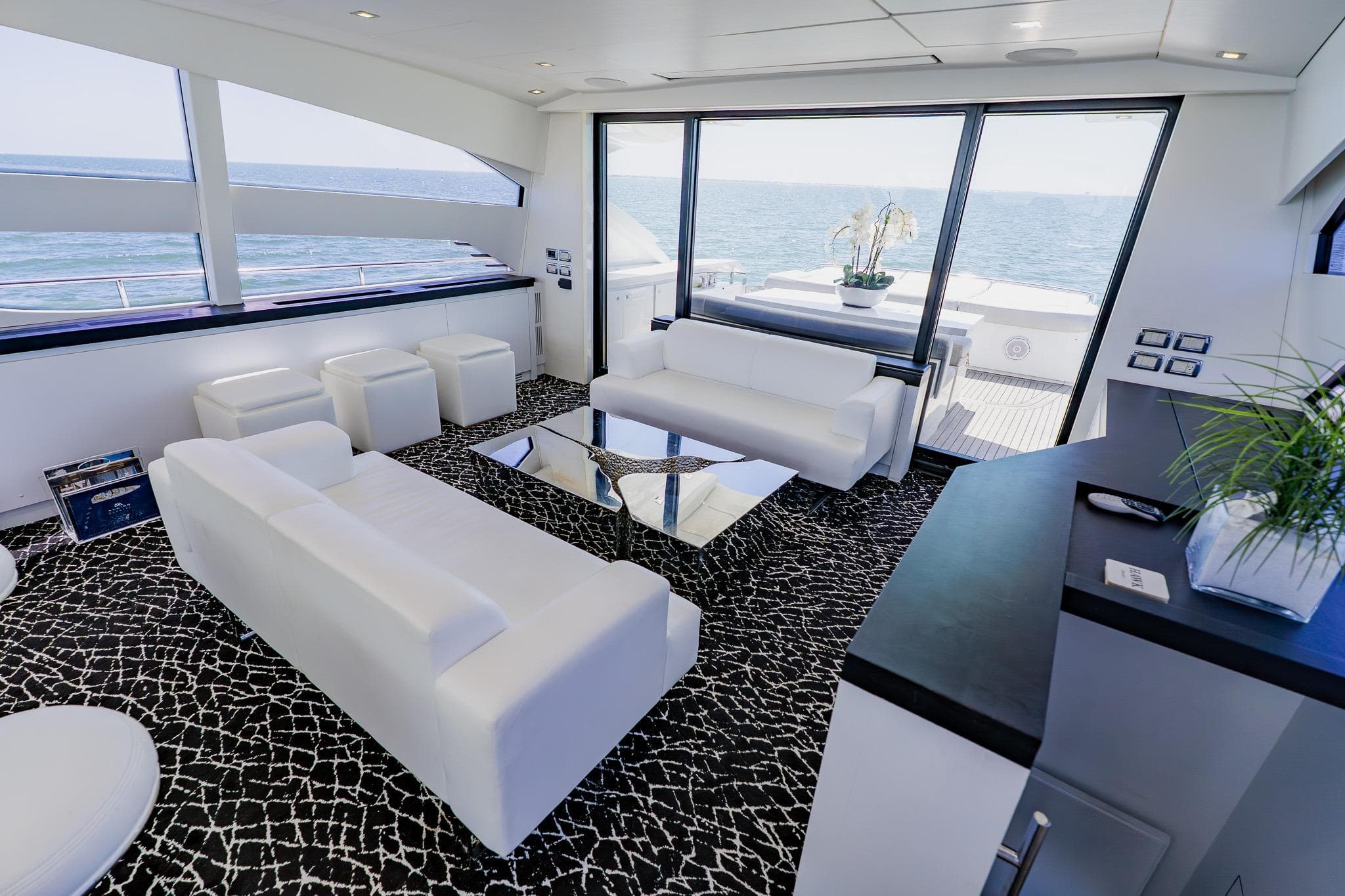 Luxurious interior of 2010 Pershing 80 yacht with modern white seating and ocean view.