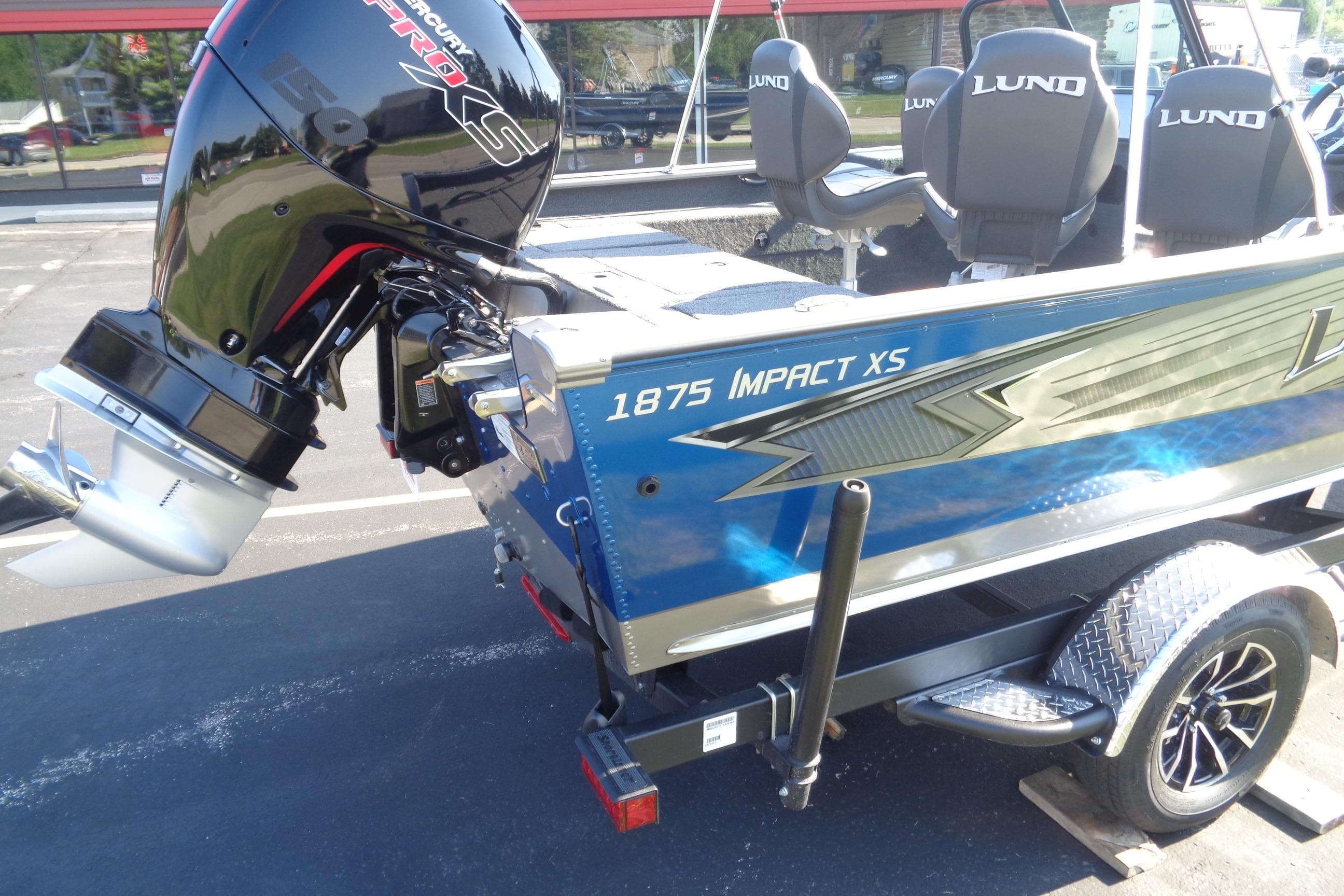 2026 Lund 1875 Impact XS Sport boat with Mercury Pro XS engine, parked on trailer.