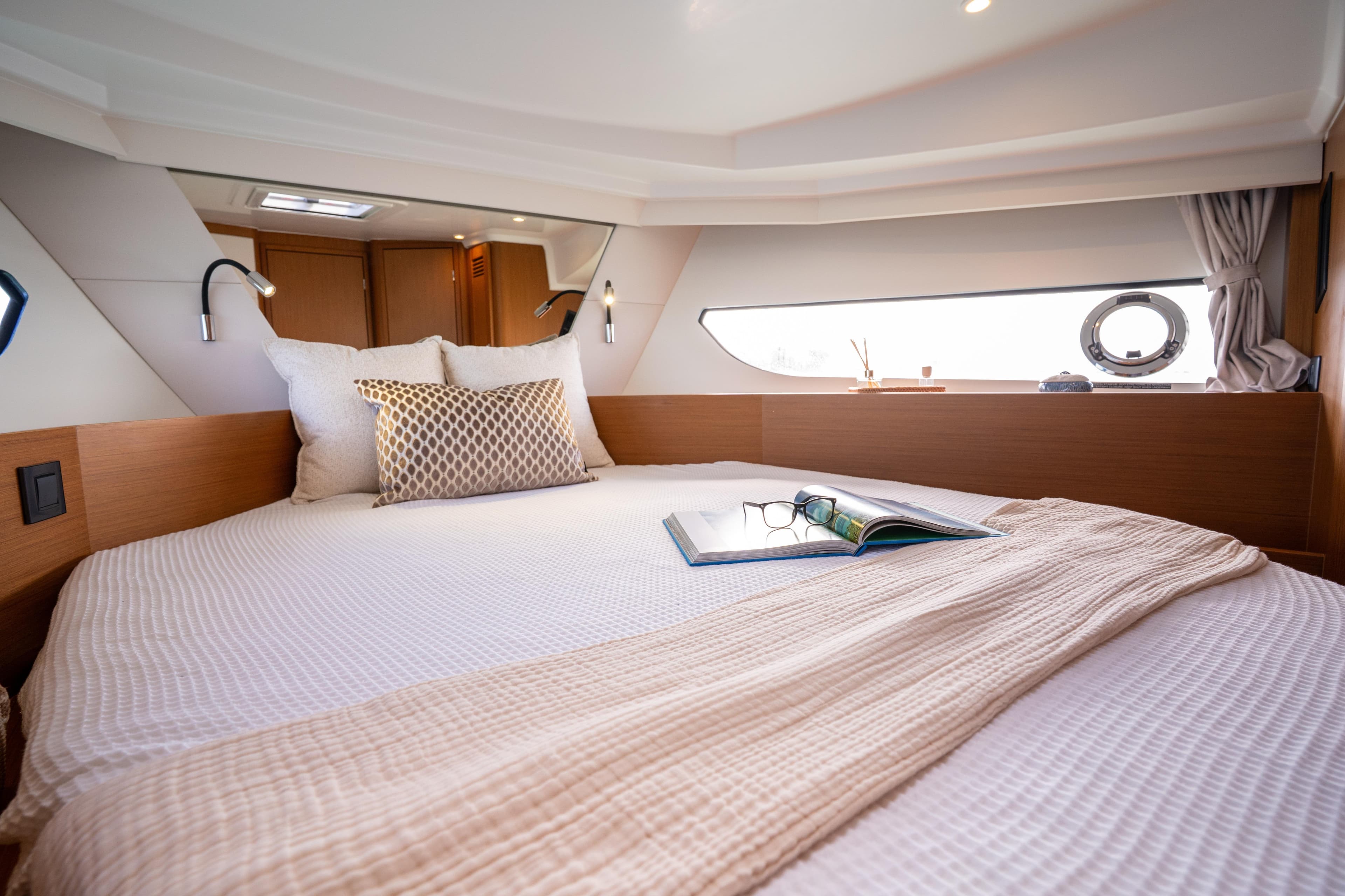 Luxurious cabin interior of 2026 Beneteau Swift Trawler 37 Fly with cozy bedding.