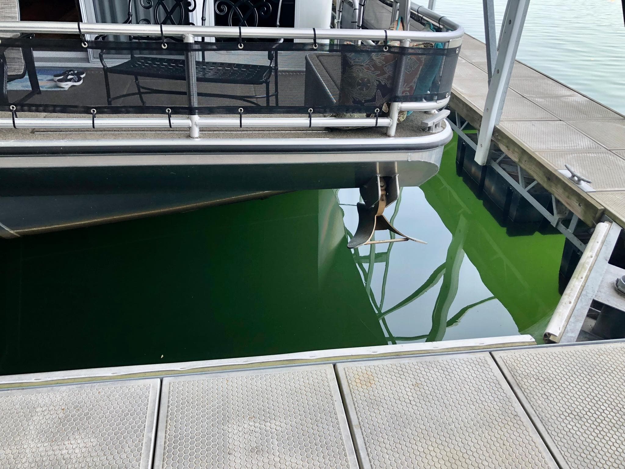 Thoroughbred 67x17 houseboat docked, propeller visible in green water, 2016 model.