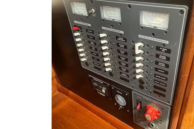 Electrical panel of a 1983 Wauquiez 38 sailboat with switches and gauges.