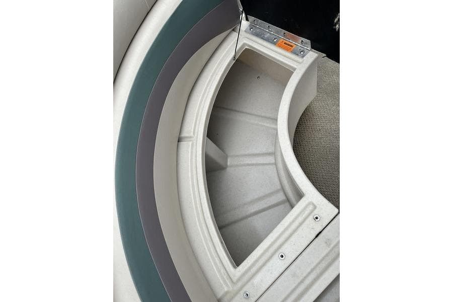 Storage compartment in 2011 South Bay 420 CR boat, featuring curved seating and carpeted flooring.