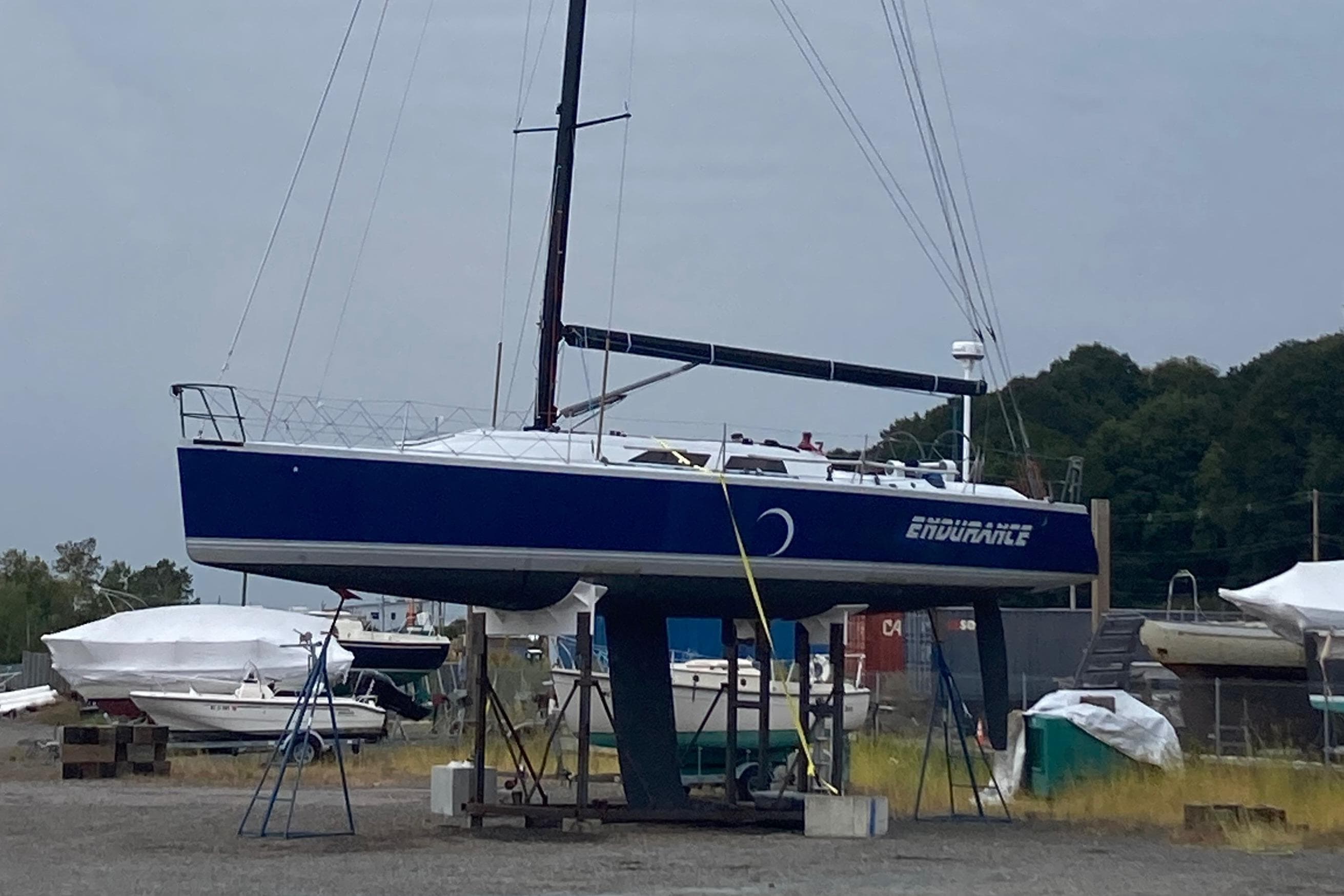 Sailboat "Endurance" on land, Tripp 47 model, 1995, in a boatyard setting.