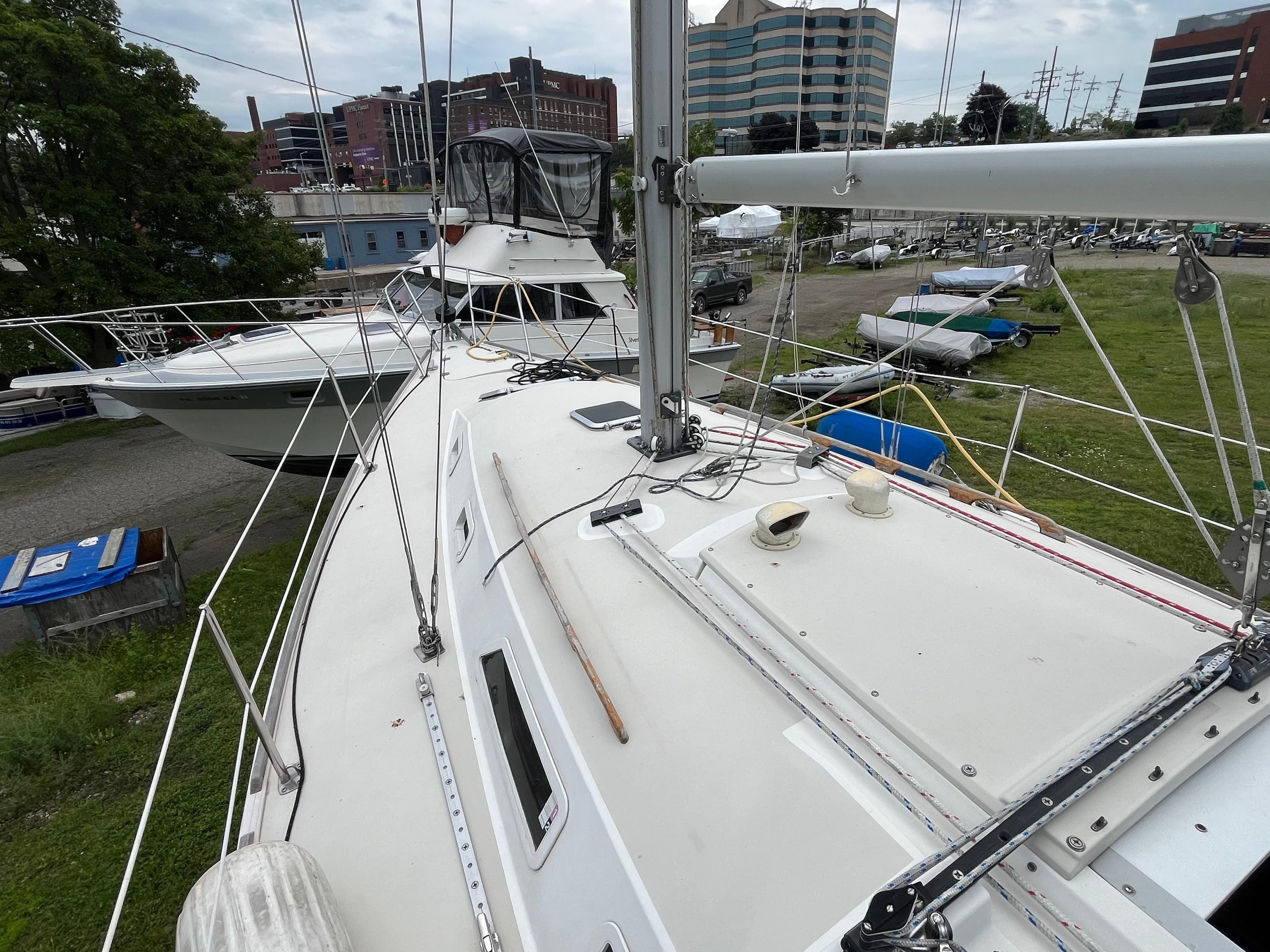Pearson 33-2 sailboat from 1986 docked, with urban buildings in the background.