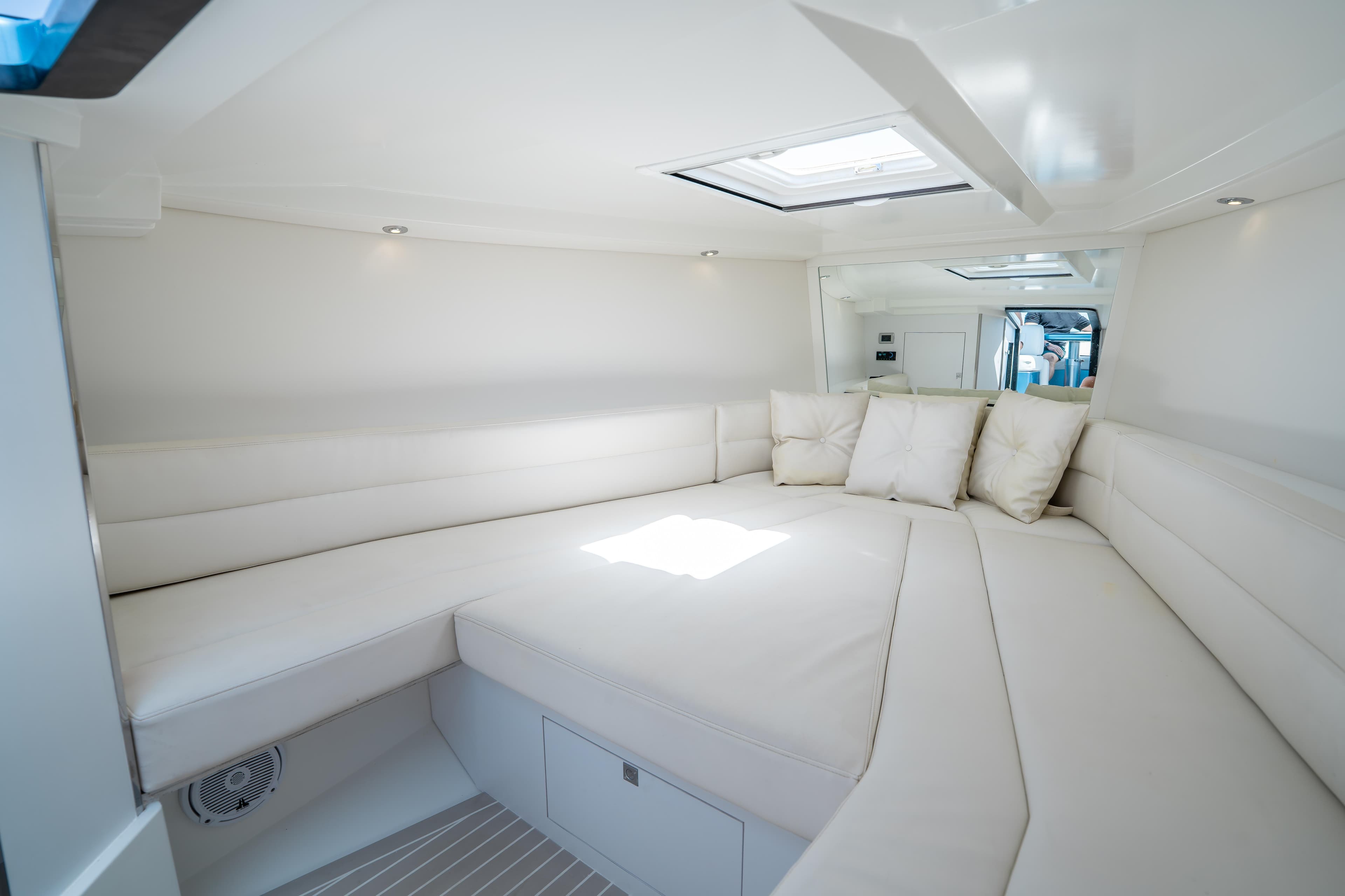 Luxurious interior of 2018 VanDutch 30 yacht with white seating and cushions.