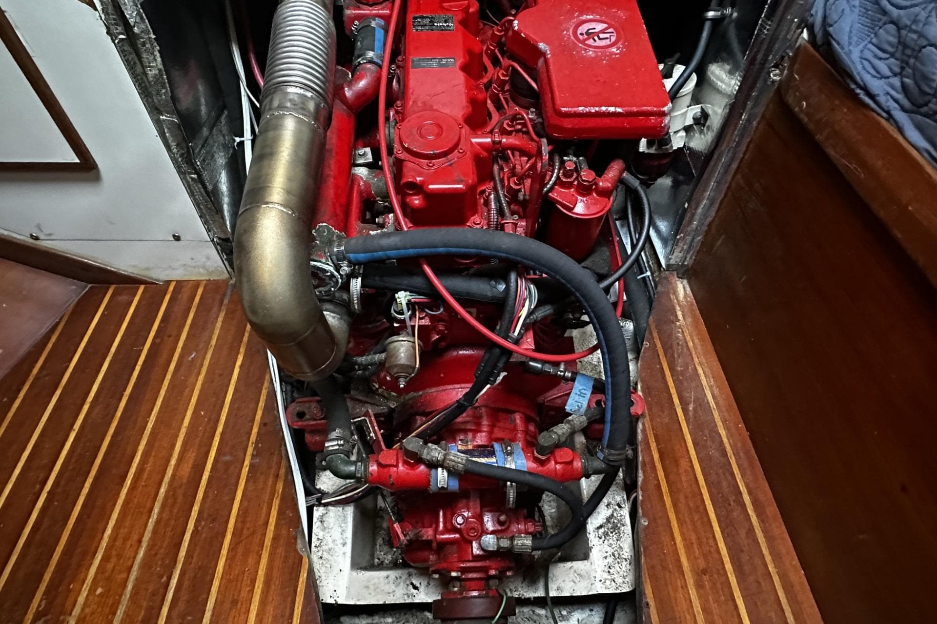 Engine compartment of a 1981 Pearson 424 sailboat, featuring a red marine engine.
