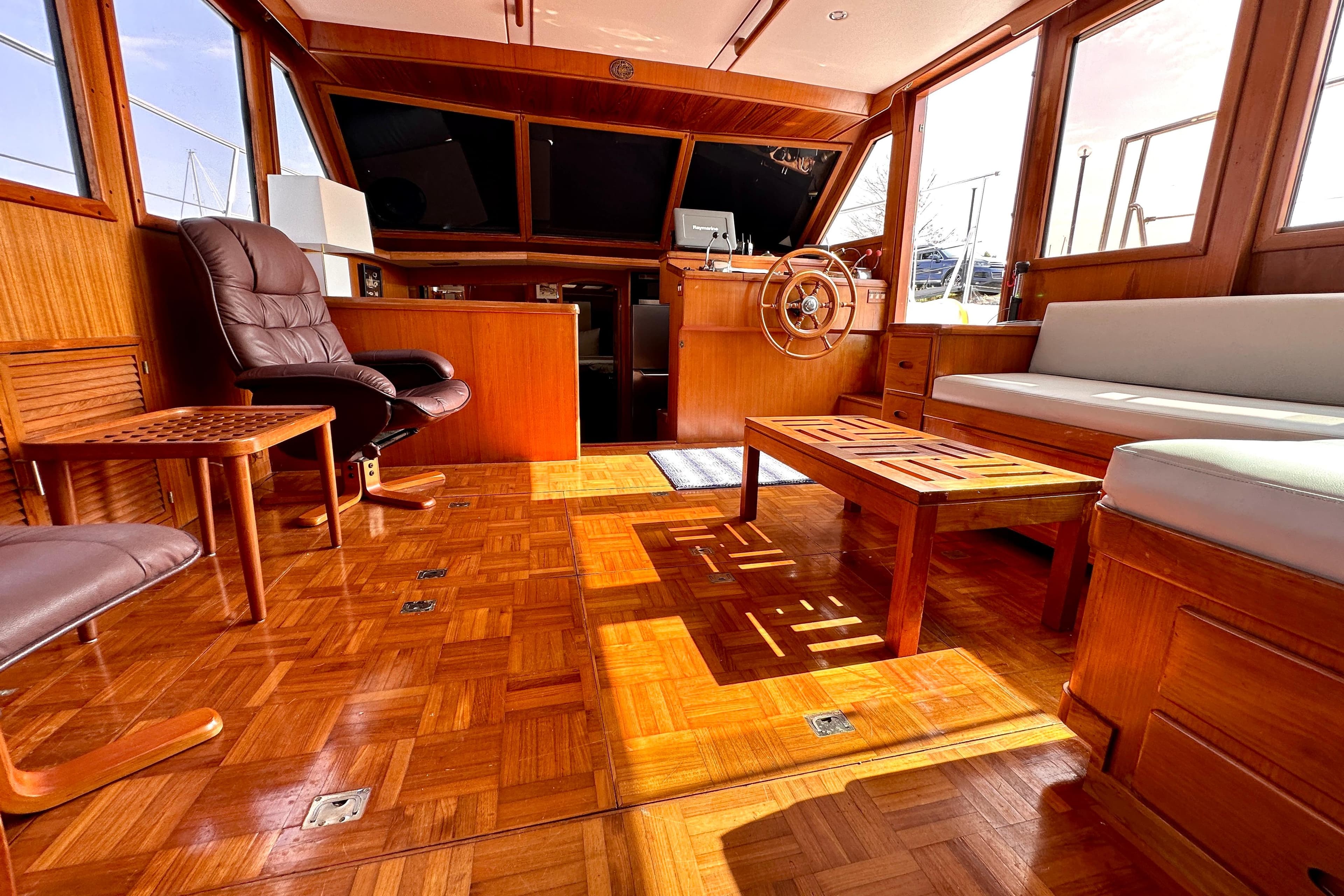Interior of 1987 Marine Trader 47 Tradewinds yacht with wooden furnishings and helm.