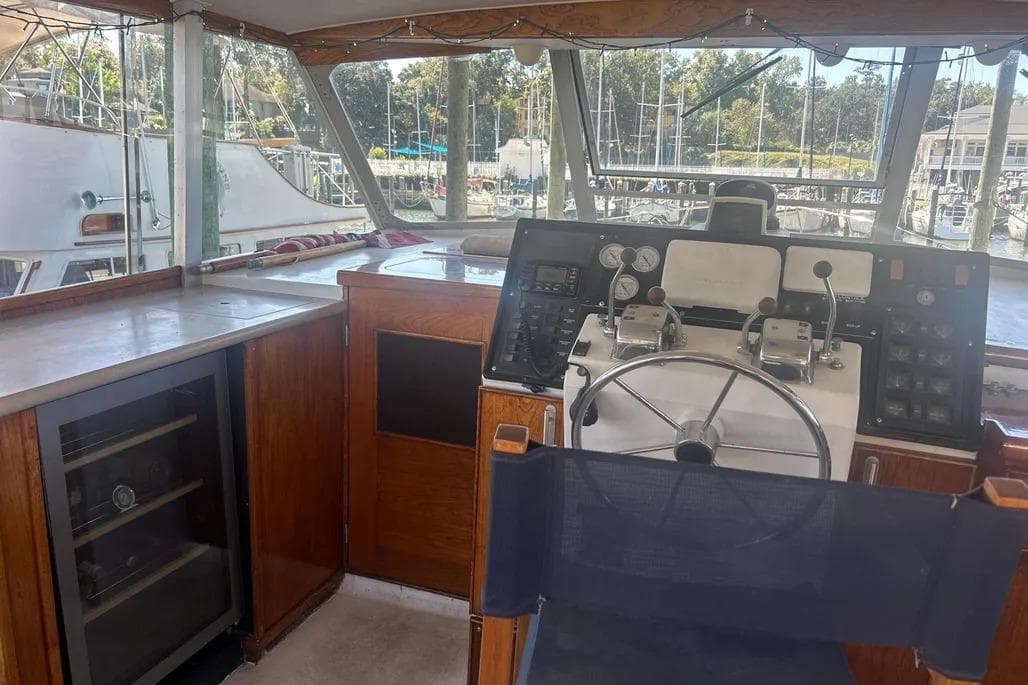 1978 Chris-Craft 45 Commander helm with steering wheel, controls, and marina view.