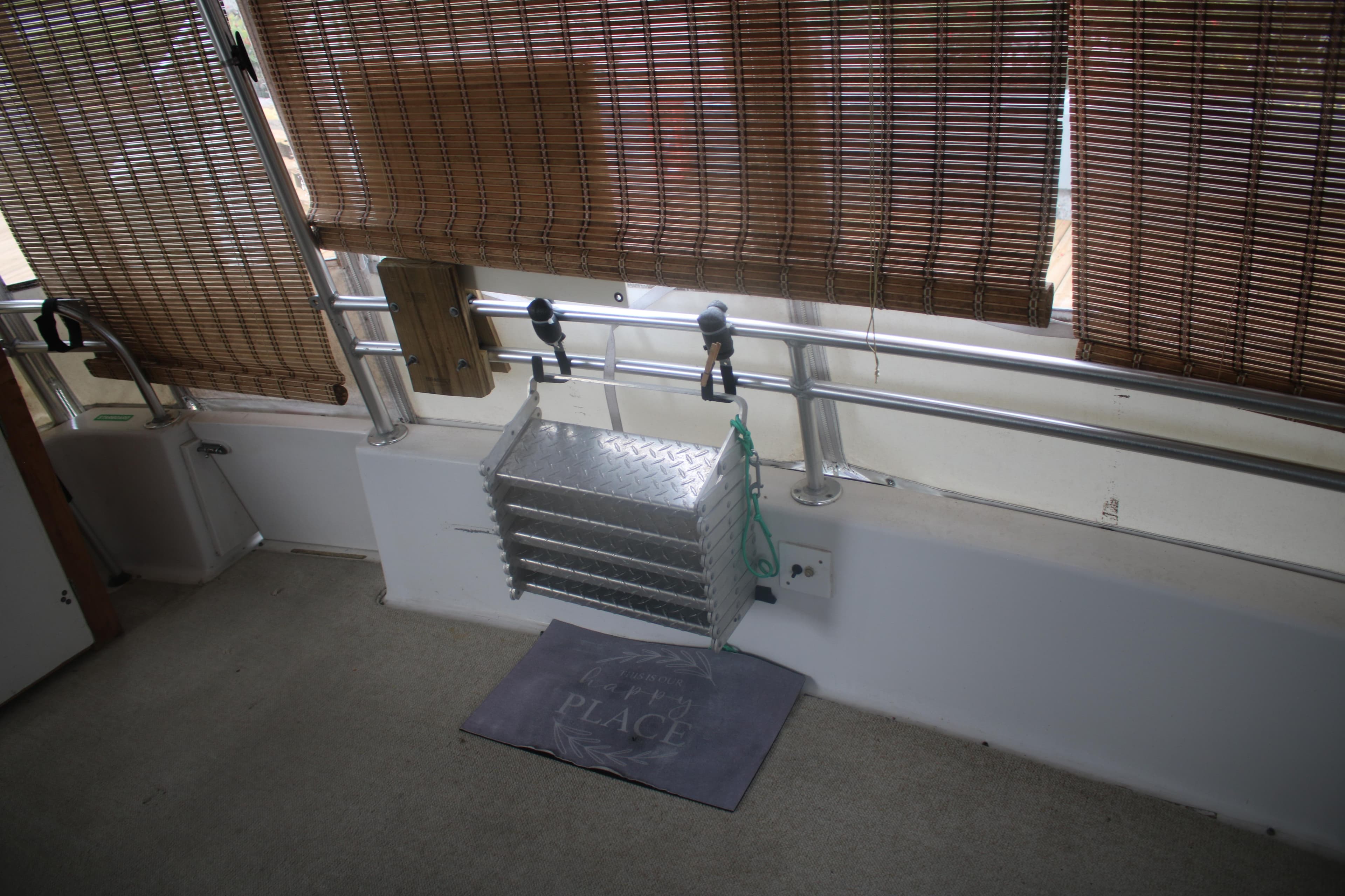 Interior of 1998 Mainship 47 Motor Yacht with bamboo blinds and metal railing.