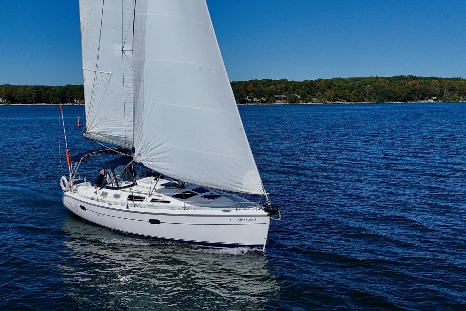 Sailboat Hunter 356, 2003 model, cruising on a clear blue lake under sunny skies.