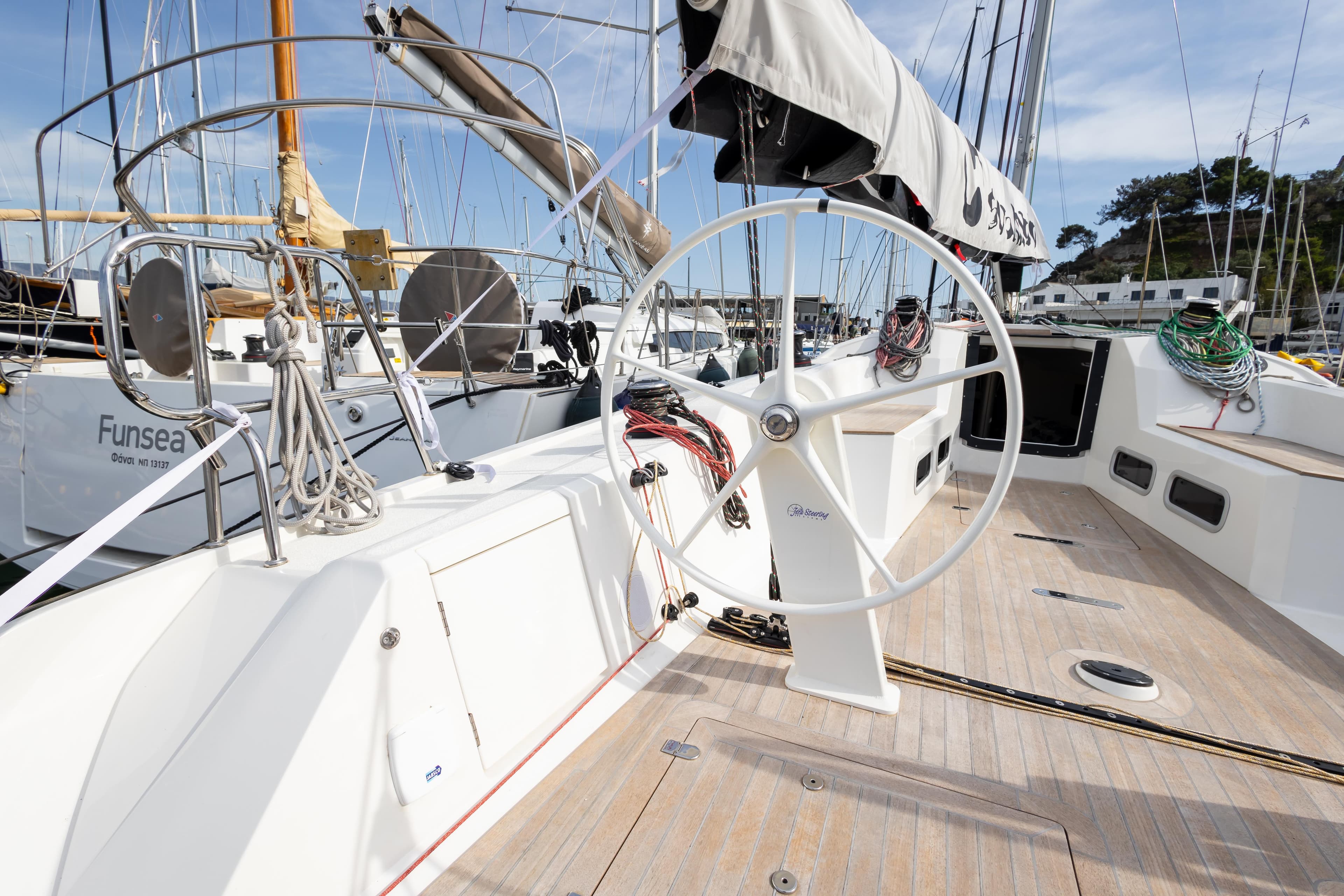 Italia Yachts IY11.98 Bellissima 2023 sailboat cockpit with steering wheel and deck view.