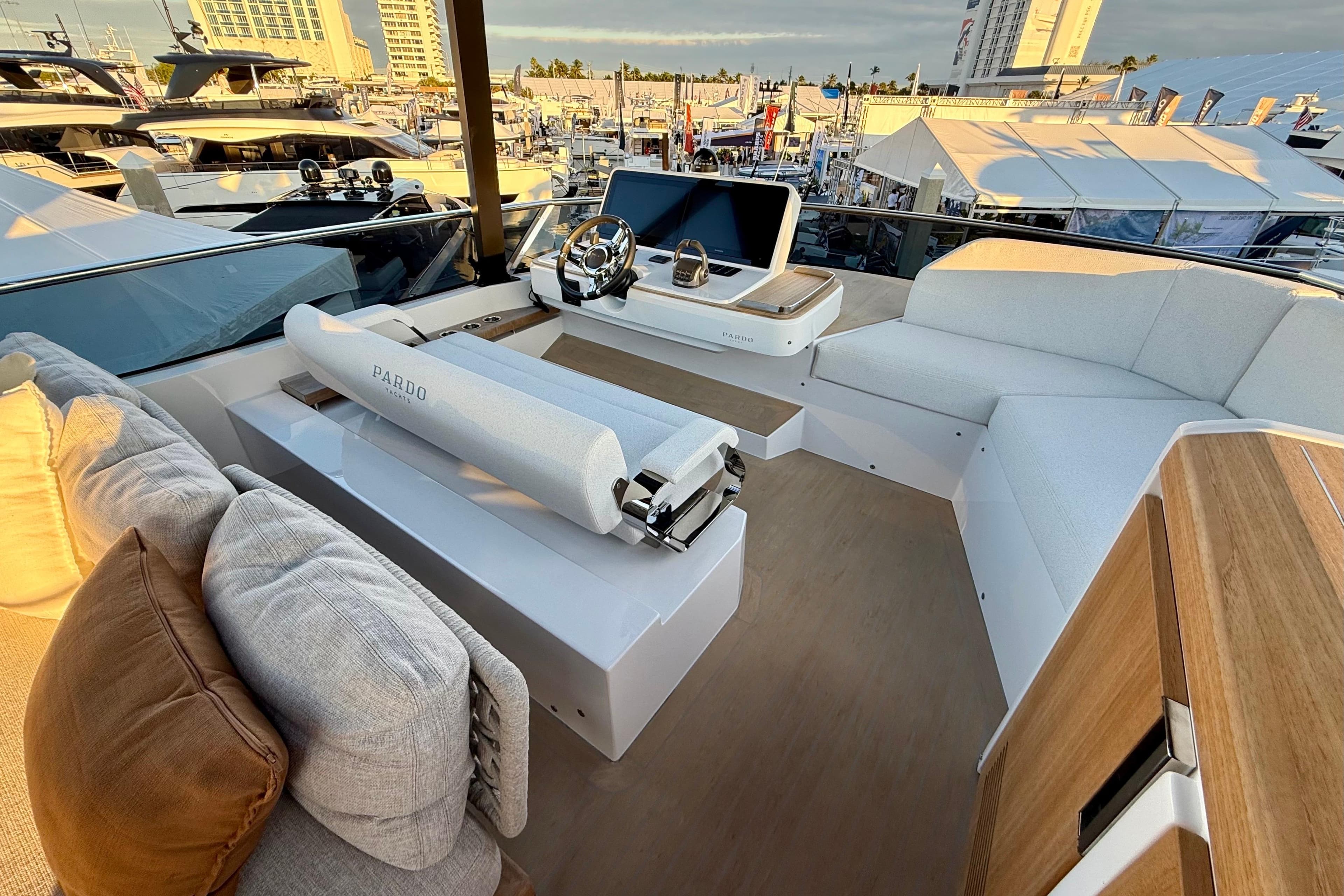 Luxurious 2026 Pardo Yachts E72 interior with modern helm and plush seating at a marina.