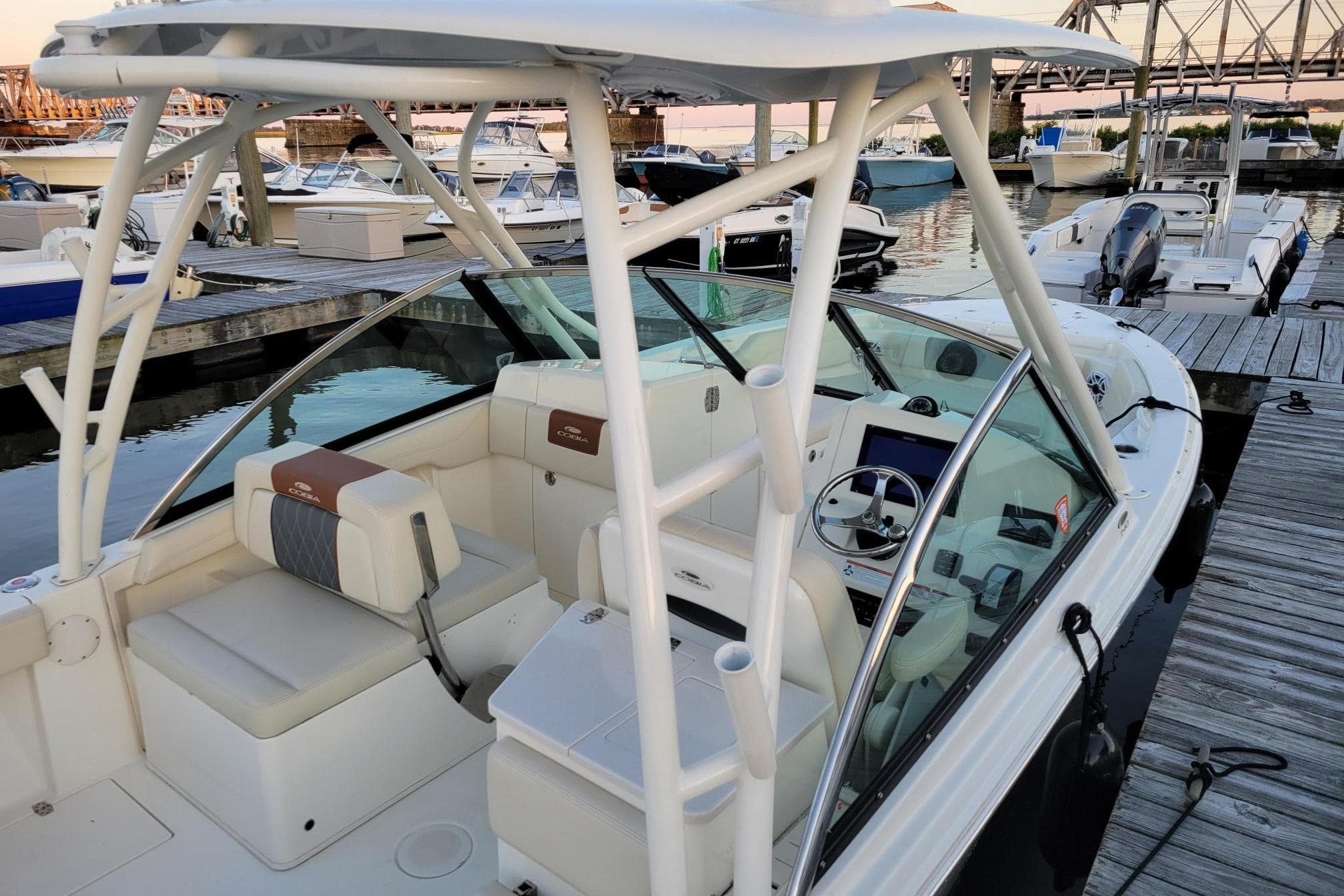 2021 Cobia 240 Dual Console boat docked at marina, featuring spacious seating and modern controls.