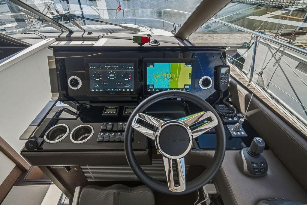 Cockpit of 2024 Prestige 520 yacht with advanced navigation systems and sleek steering wheel.