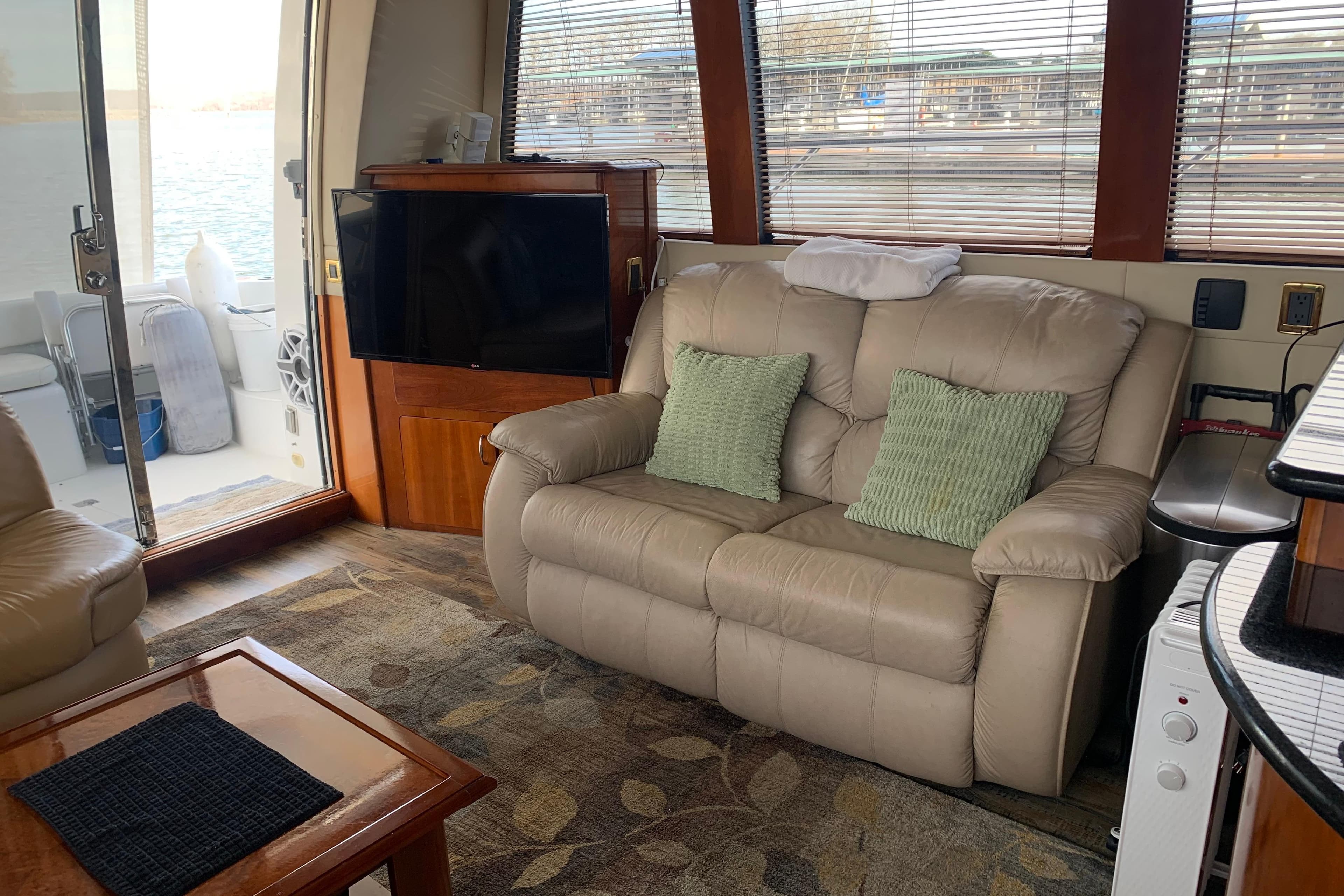Interior of 2004 Carver 570 Voyager Pilothouse with beige sofa and TV.