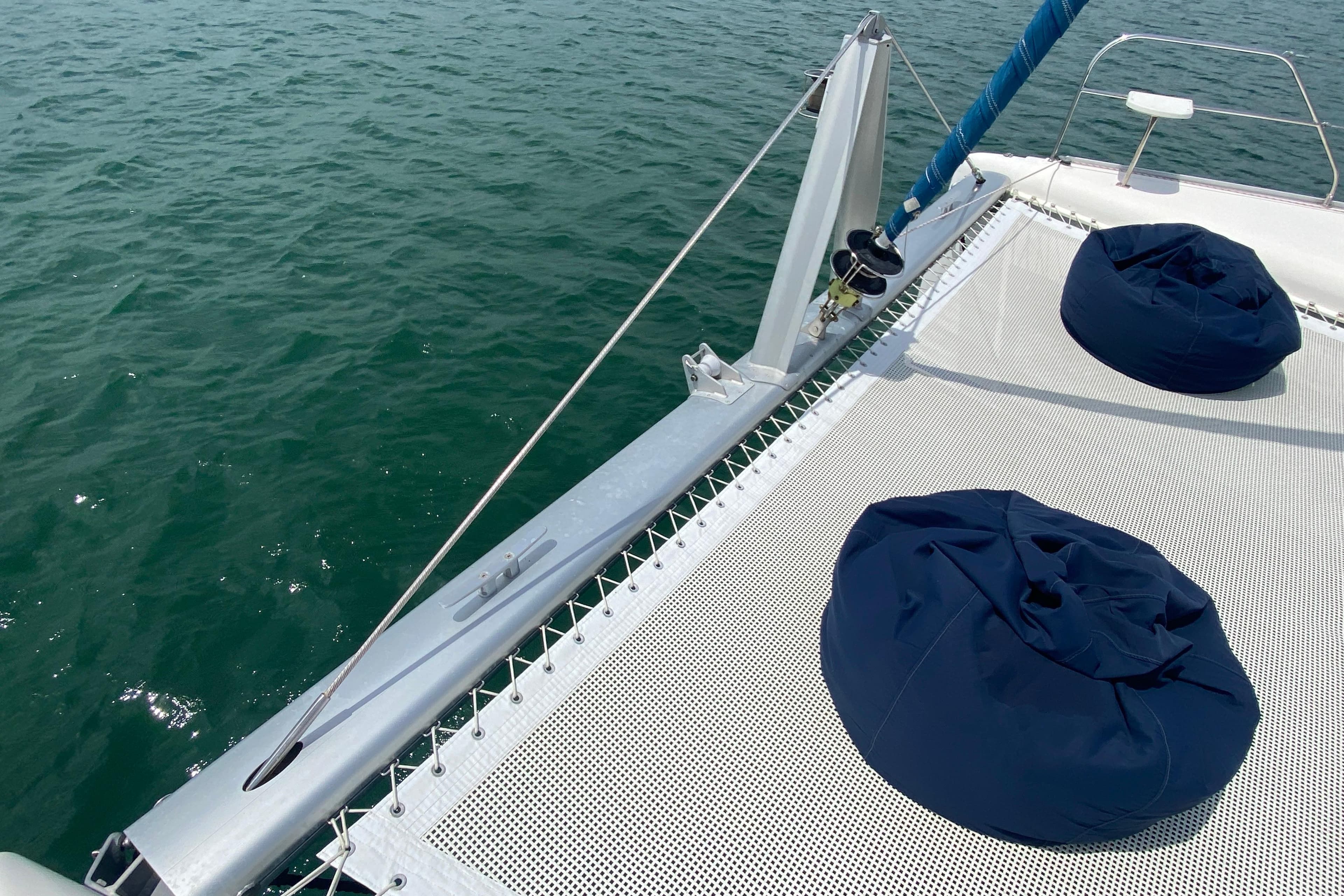 Catamaran deck with blue bean bags, Leopard 46, 2010 model, on calm water.