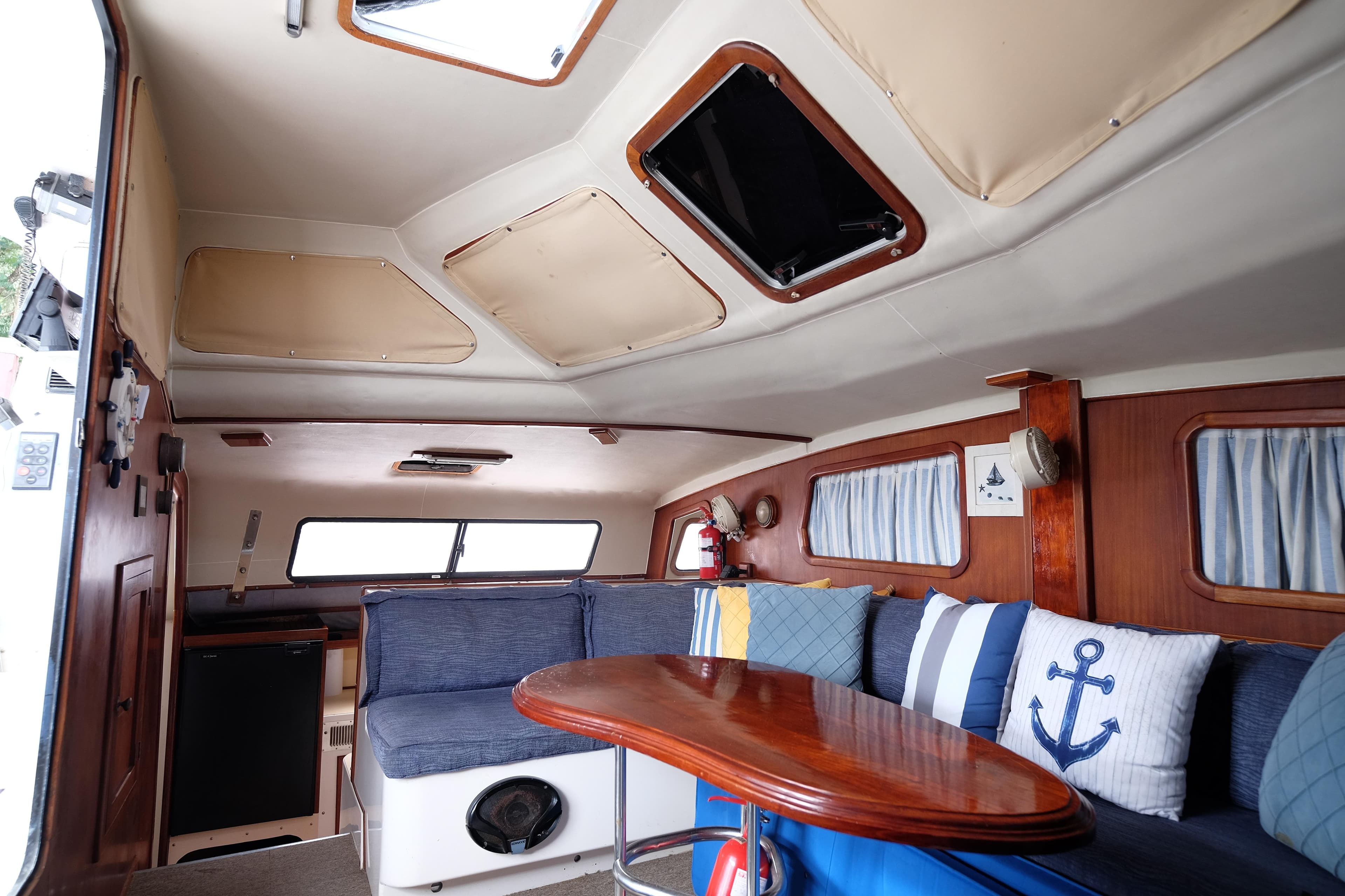 Interior of a 1996 Simpson Inspiration boat with cozy seating and nautical decor.