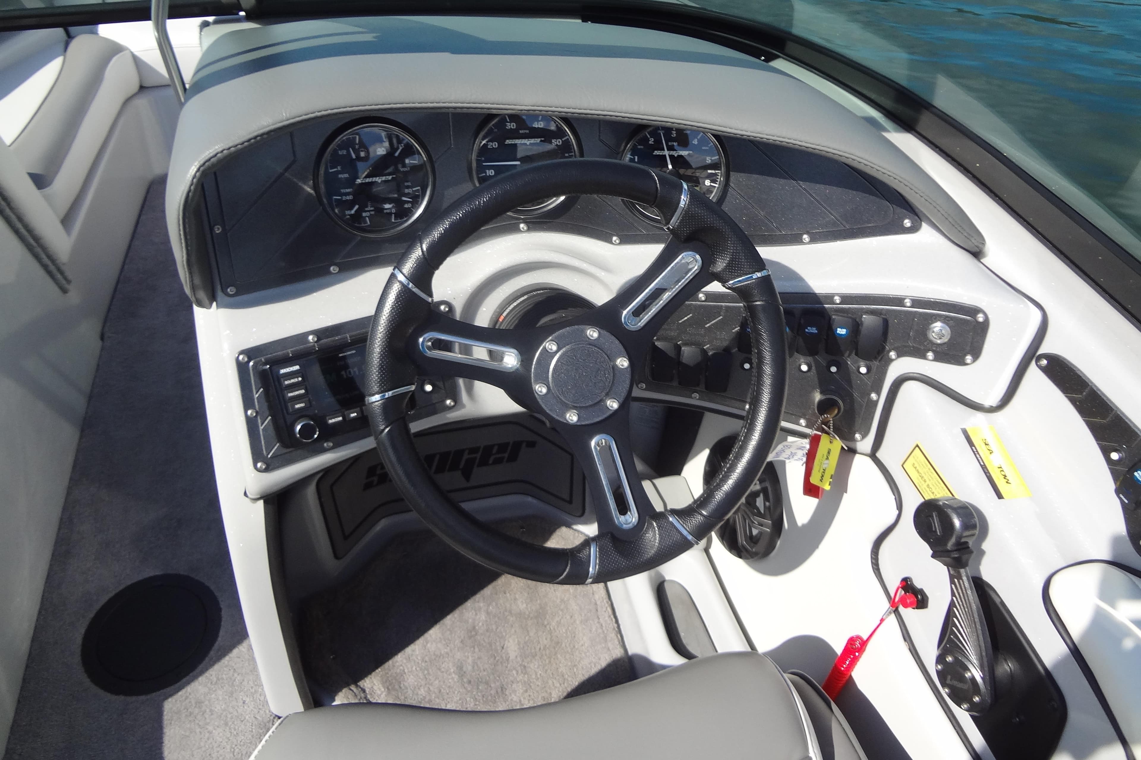 2022 Sanger V237 S boat dashboard with steering wheel and control panel.