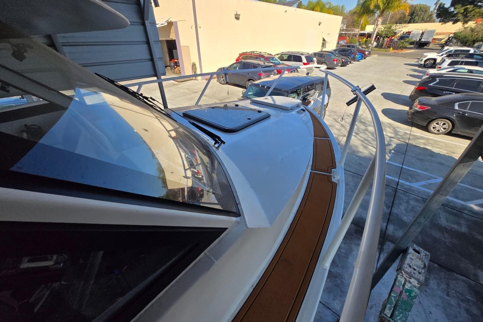 Custom Boat 34, 2025 model, docked in a parking lot with surrounding vehicles.